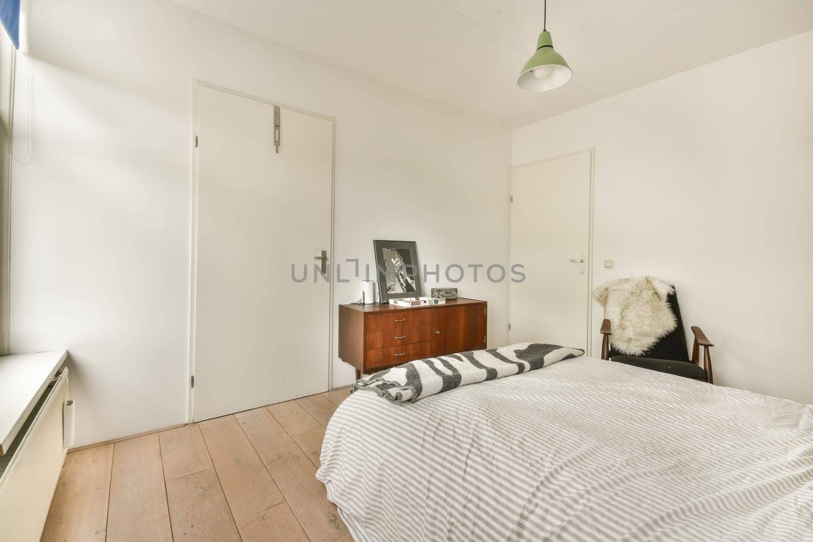 A serene and minimalist bedroom featuring a simple bed, elegant decor, and natural light filtering through the windows, creating a tranquil space.