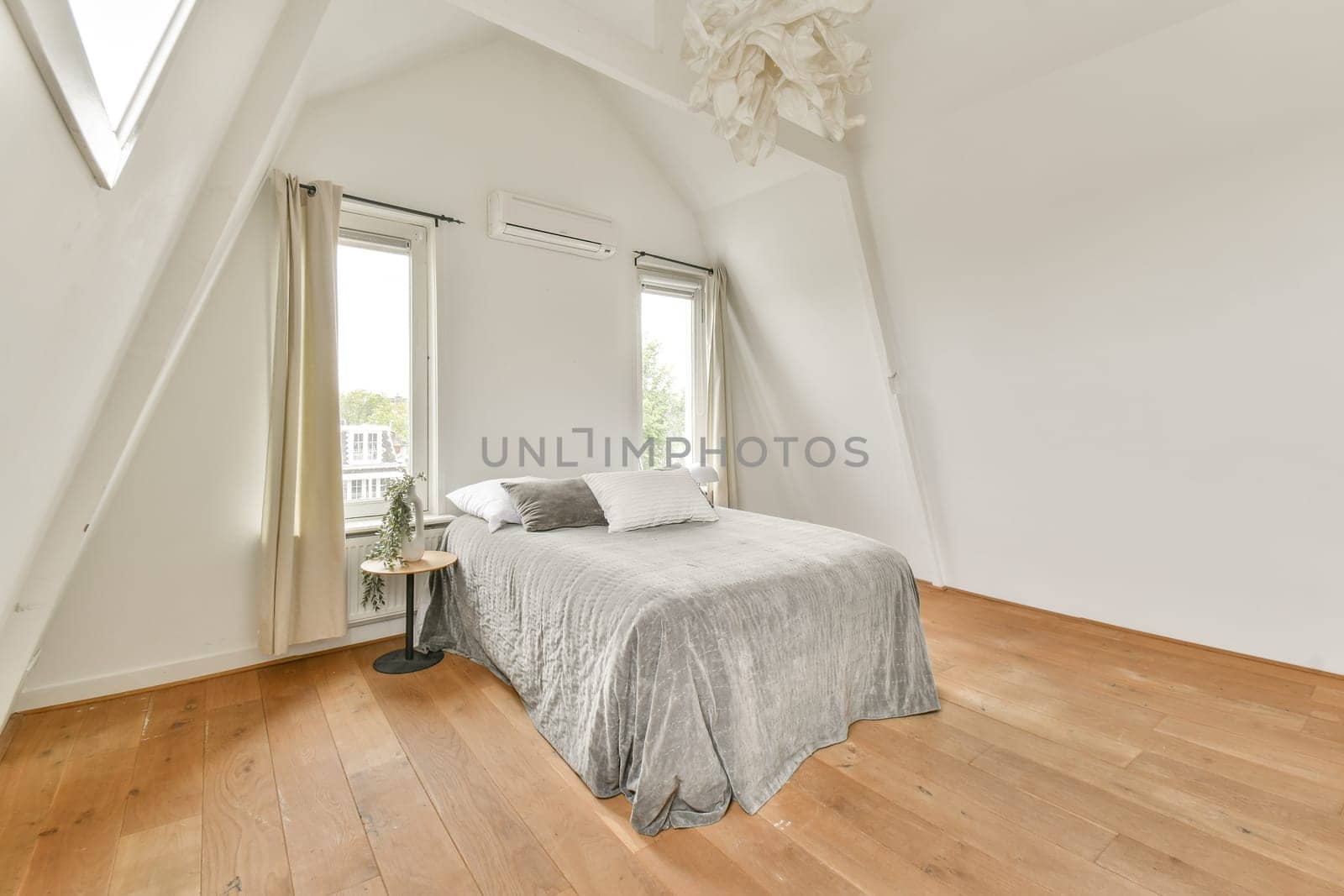 Bright and spacious minimalist bedroom design featuring a cozy bed, natural light, and wooden flooring that creates a serene atmosphere.