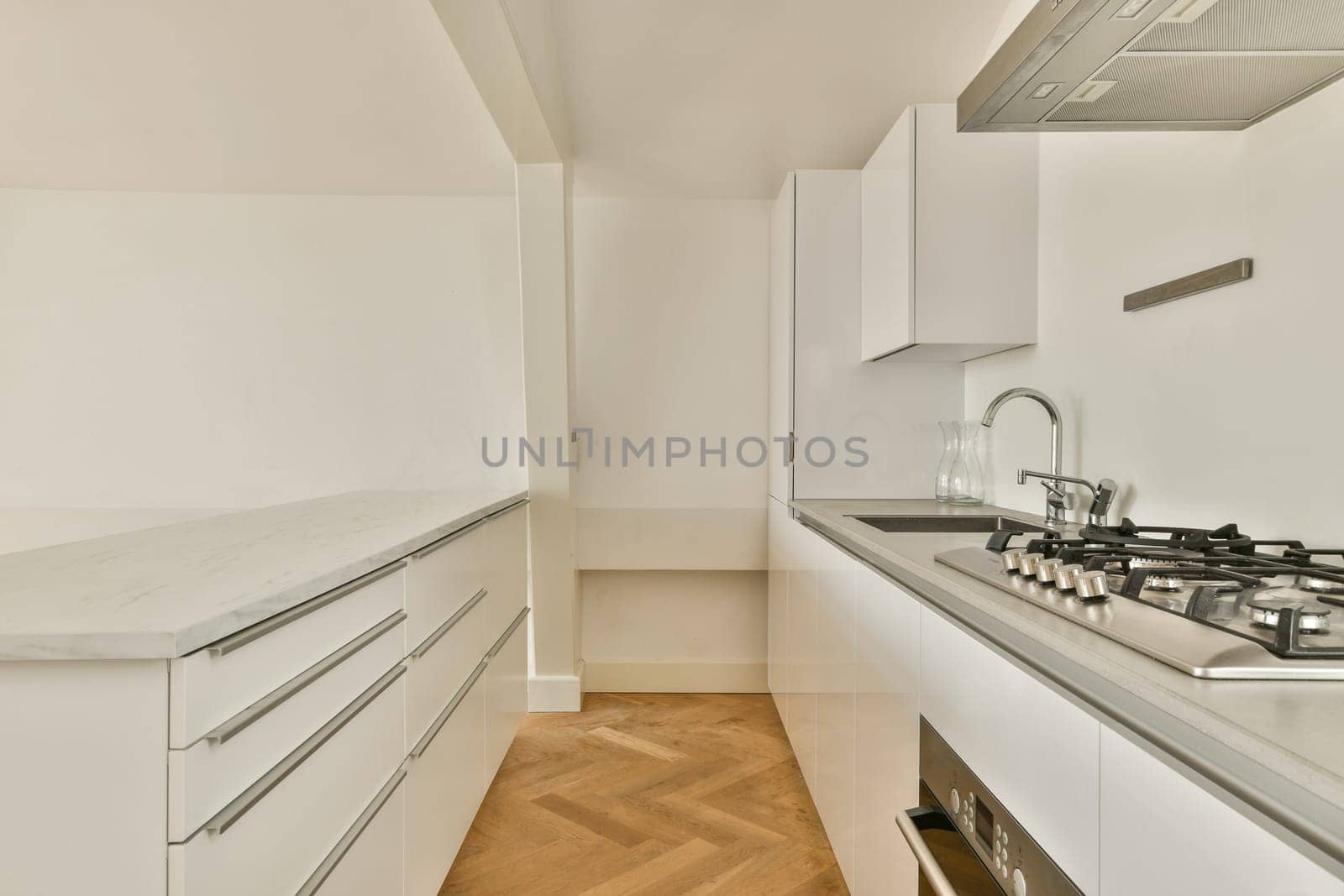 A sleek modern kitchen featuring white cabinetry, gray countertops, and elegant fixtures for a contemporary cooking space. Ideal for design enthusiasts.