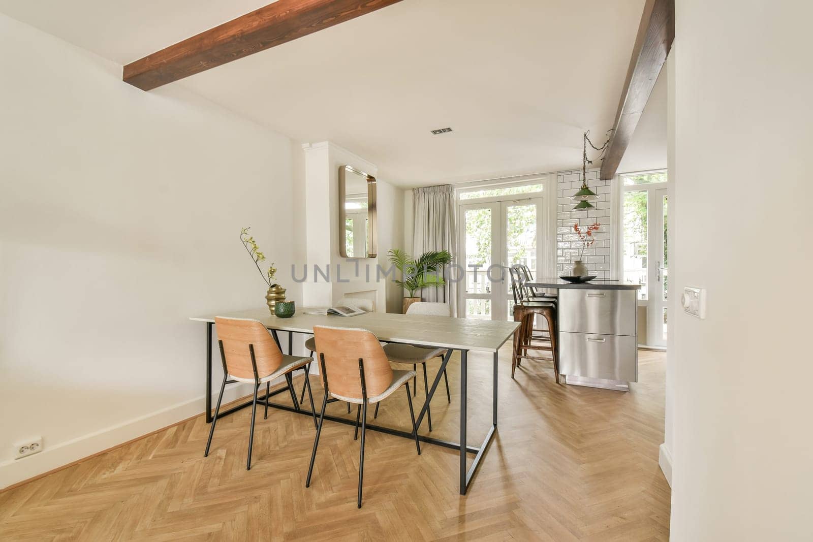 A stylish dining area featuring a minimalist table, elegant chairs, and natural light streaming through large windows, creating a vibrant atmosphere for meals.