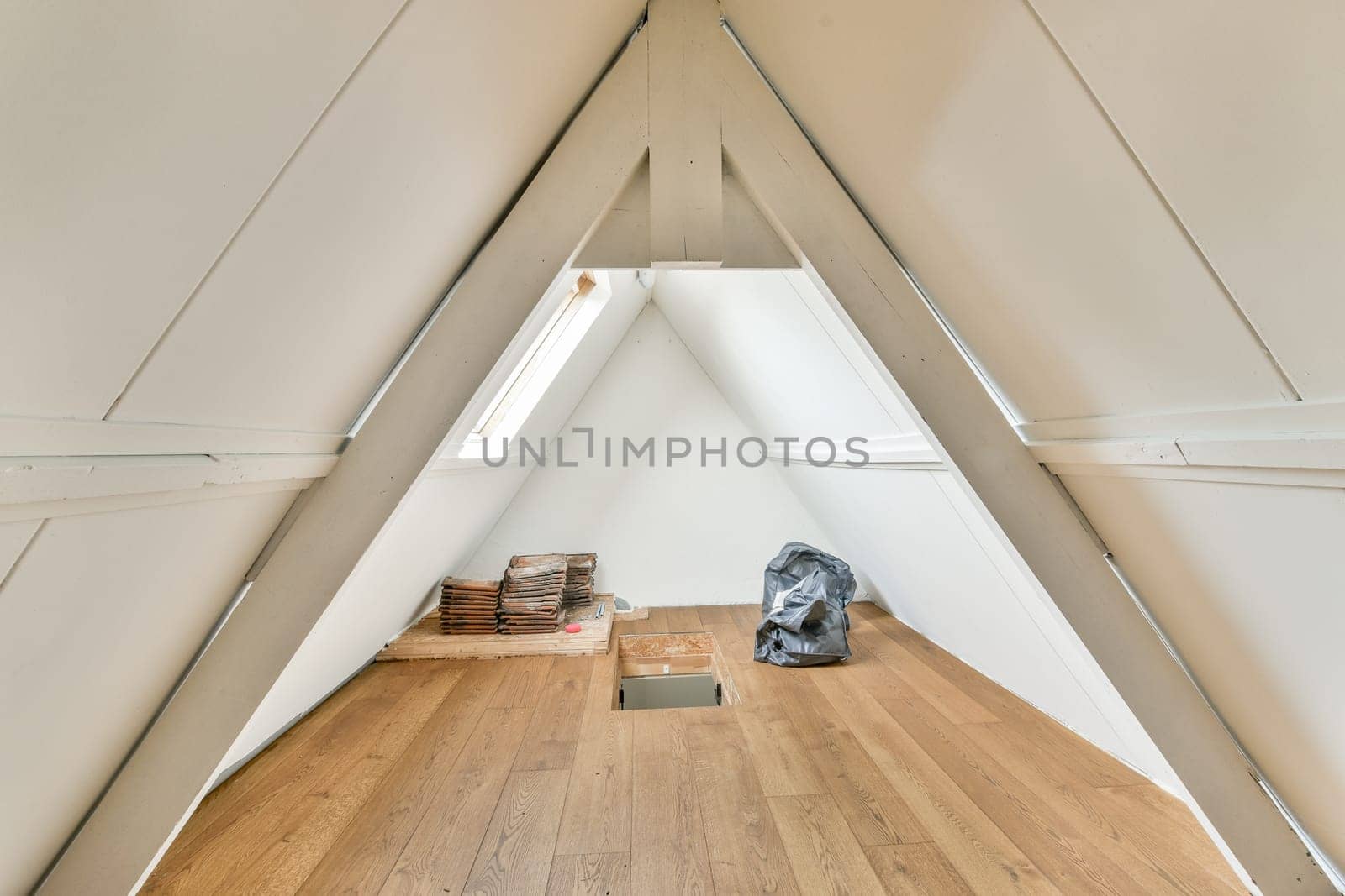 A contemporary A-frame room showcasing clean lines, wooden floors, and minimalist decor. Natural light enhances the serene ambiance in this stylish space.