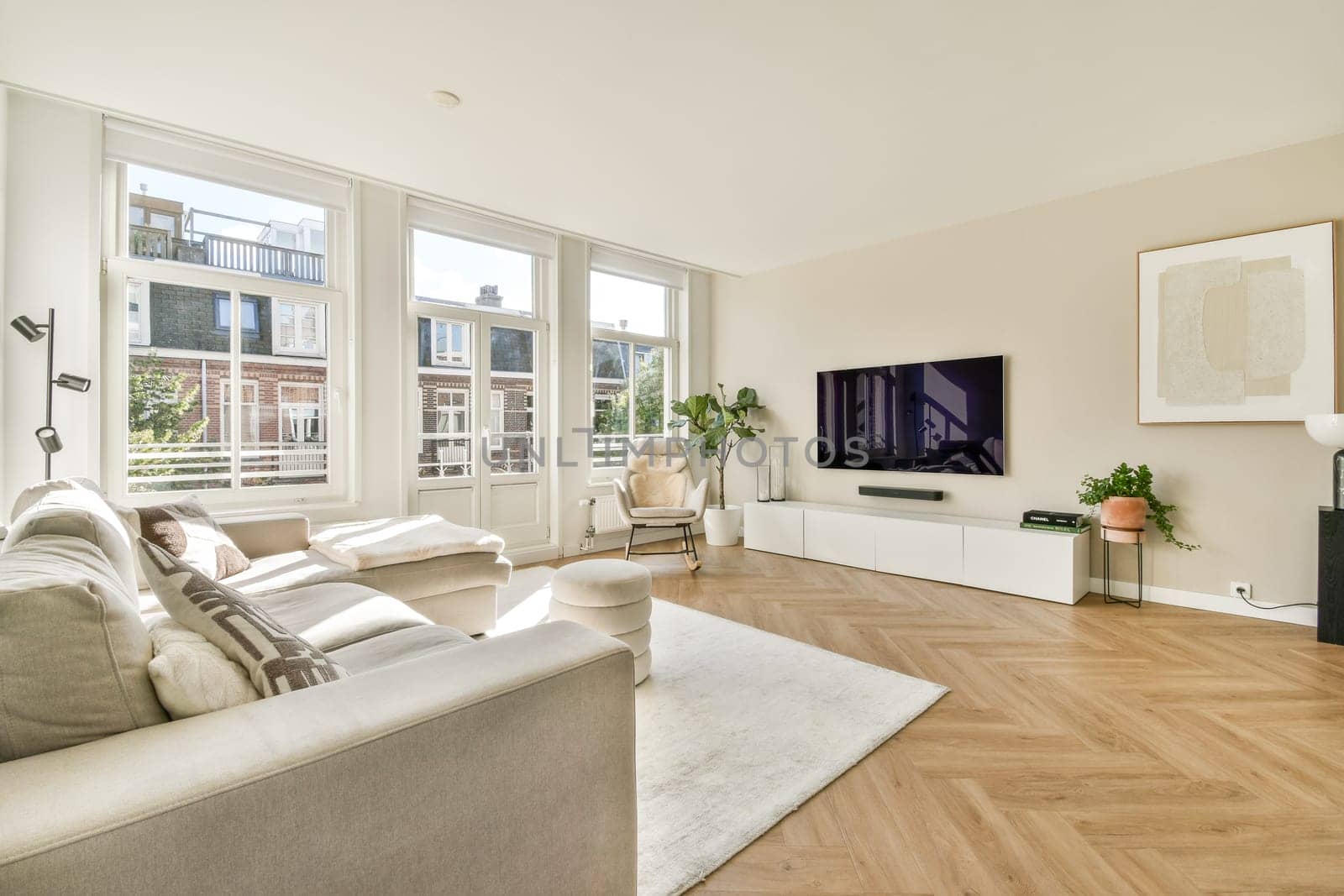 A contemporary living room featuring stylish furniture, large windows allowing natural light, and a minimalist aesthetic. Ideal for relaxation and gatherings.