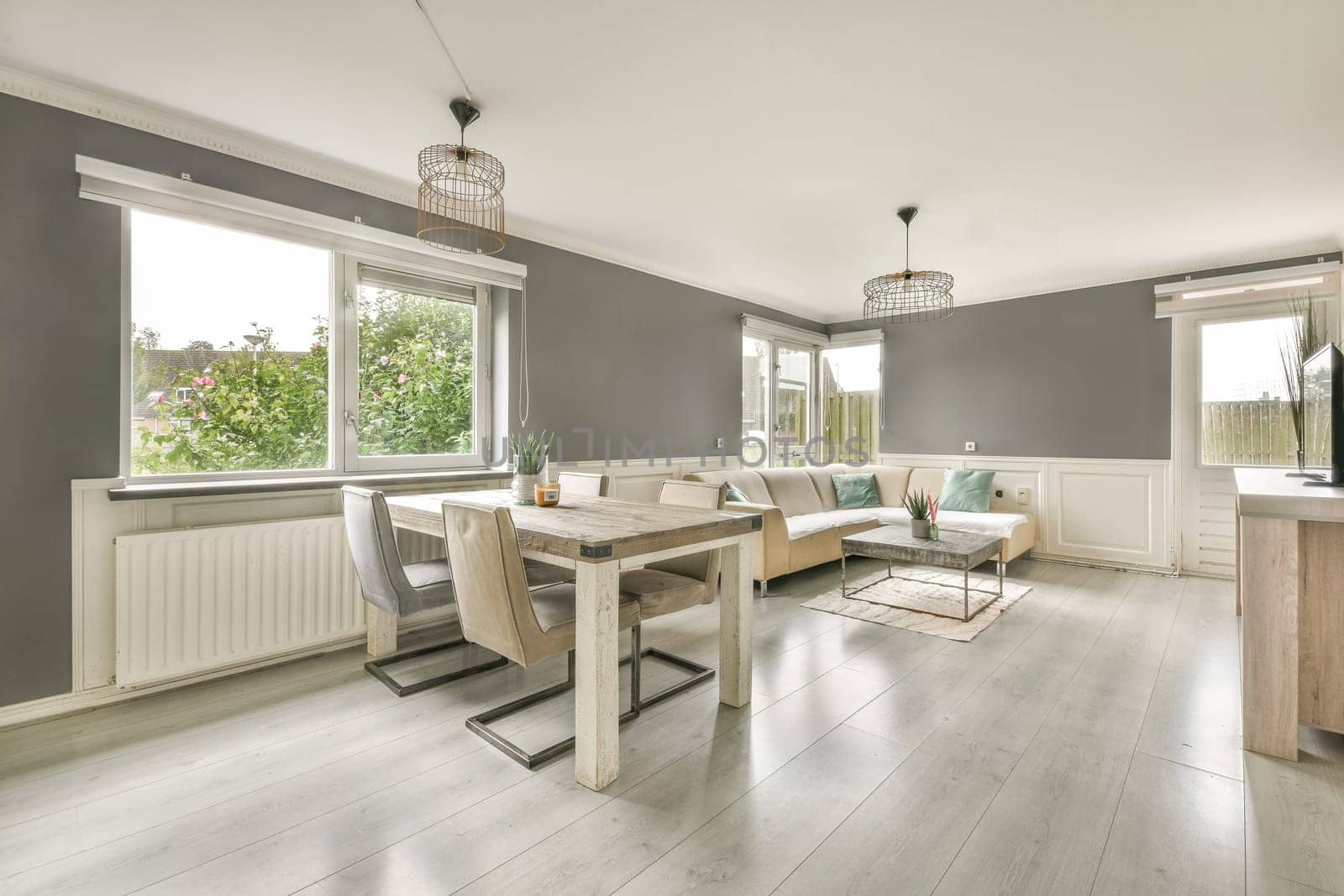 A spacious modern living room featuring stylish furnishings, large windows allowing natural light, and a cozy ambiance, perfect for relaxation and gatherings.
