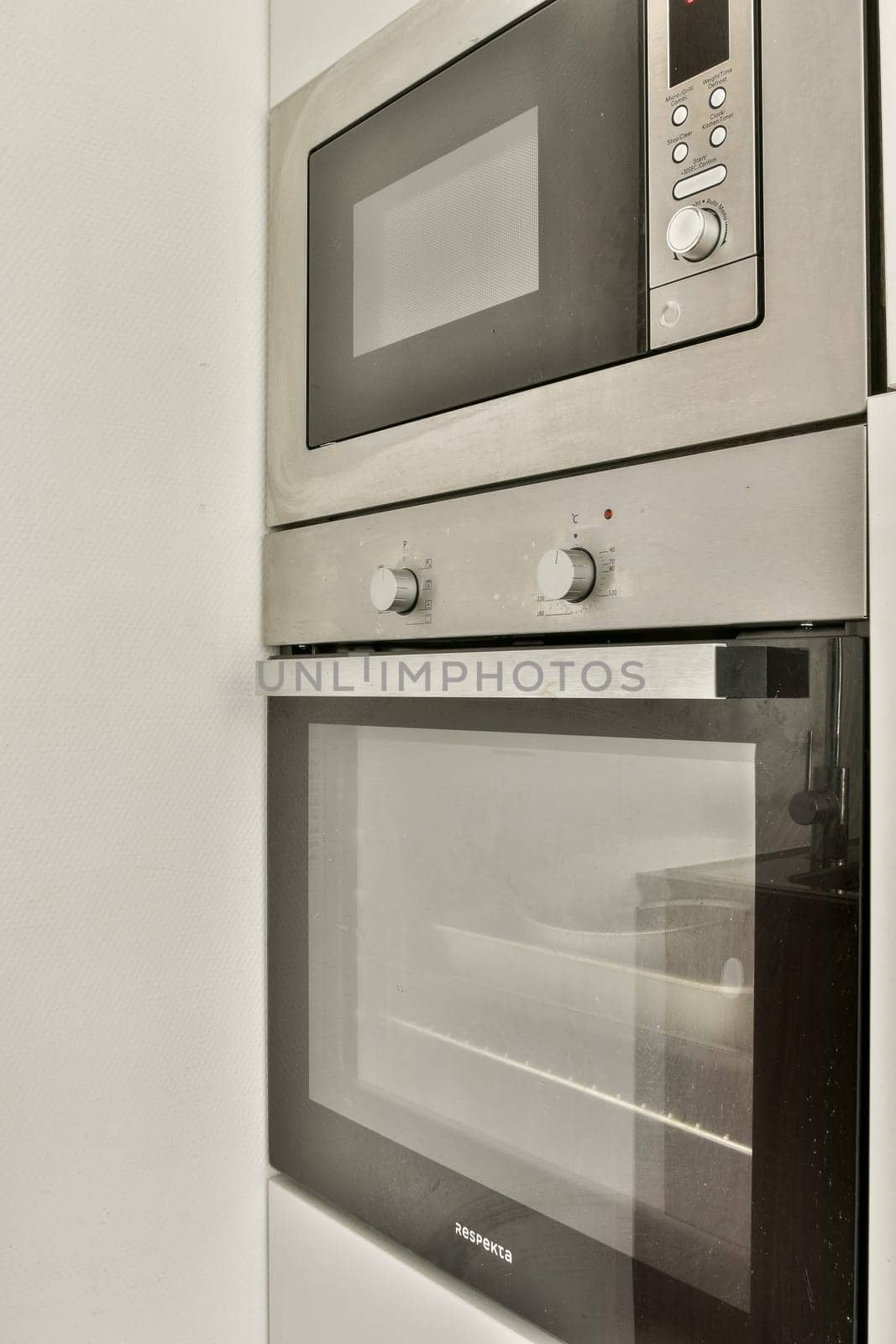 A sleek modern kitchen featuring a combination microwave and oven unit. The stainless steel finish complements the contemporary design of the kitchen space.