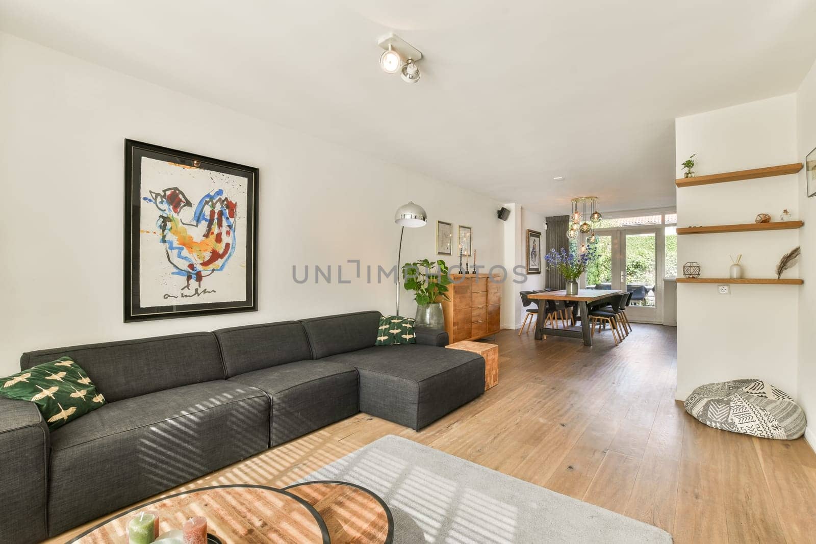 A stylish modern living room featuring a cozy sofa, wooden accents, and vibrant decor, showcasing a harmonious blend of comfort and contemporary design elements.