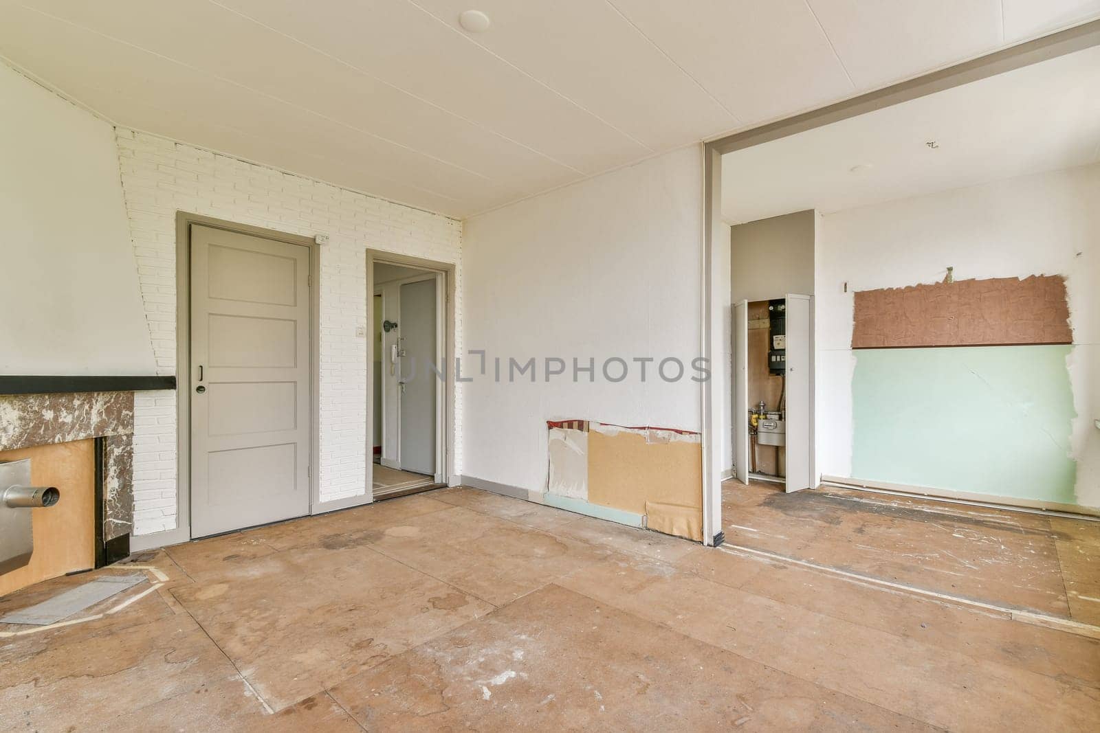 This image showcases an empty interior undergoing renovation. The walls are bare, with some areas prepared for finishing touches. The flooring appears unfinished.