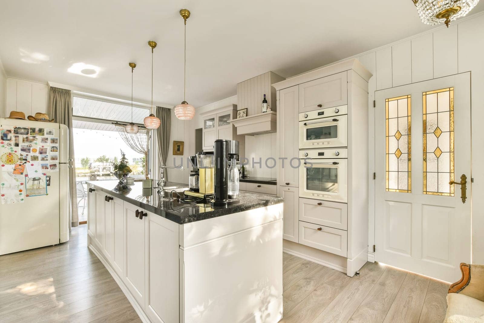A stylish kitchen featuring white cabinets, modern appliances, and a spacious layout illuminated by natural light, perfect for cooking and gathering.