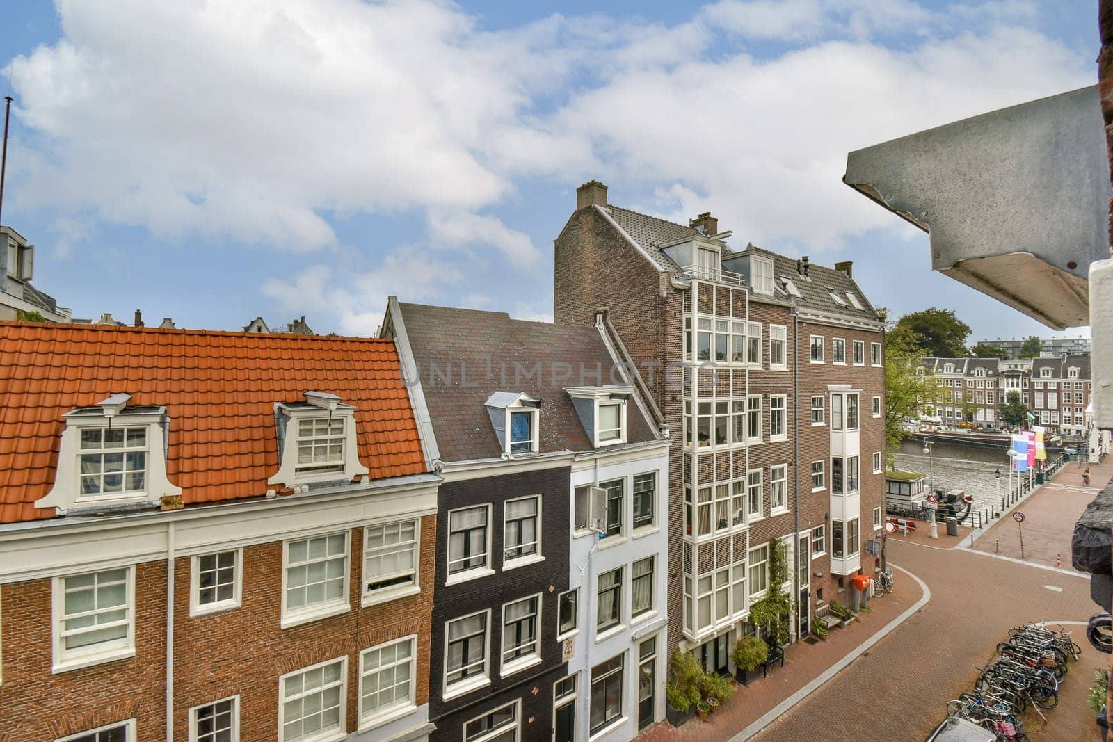 Colorful historic buildings line the canals of Amsterdam, showcasing Dutch architecture and vibrant city life. A delightful blend of culture and modernity awaits.