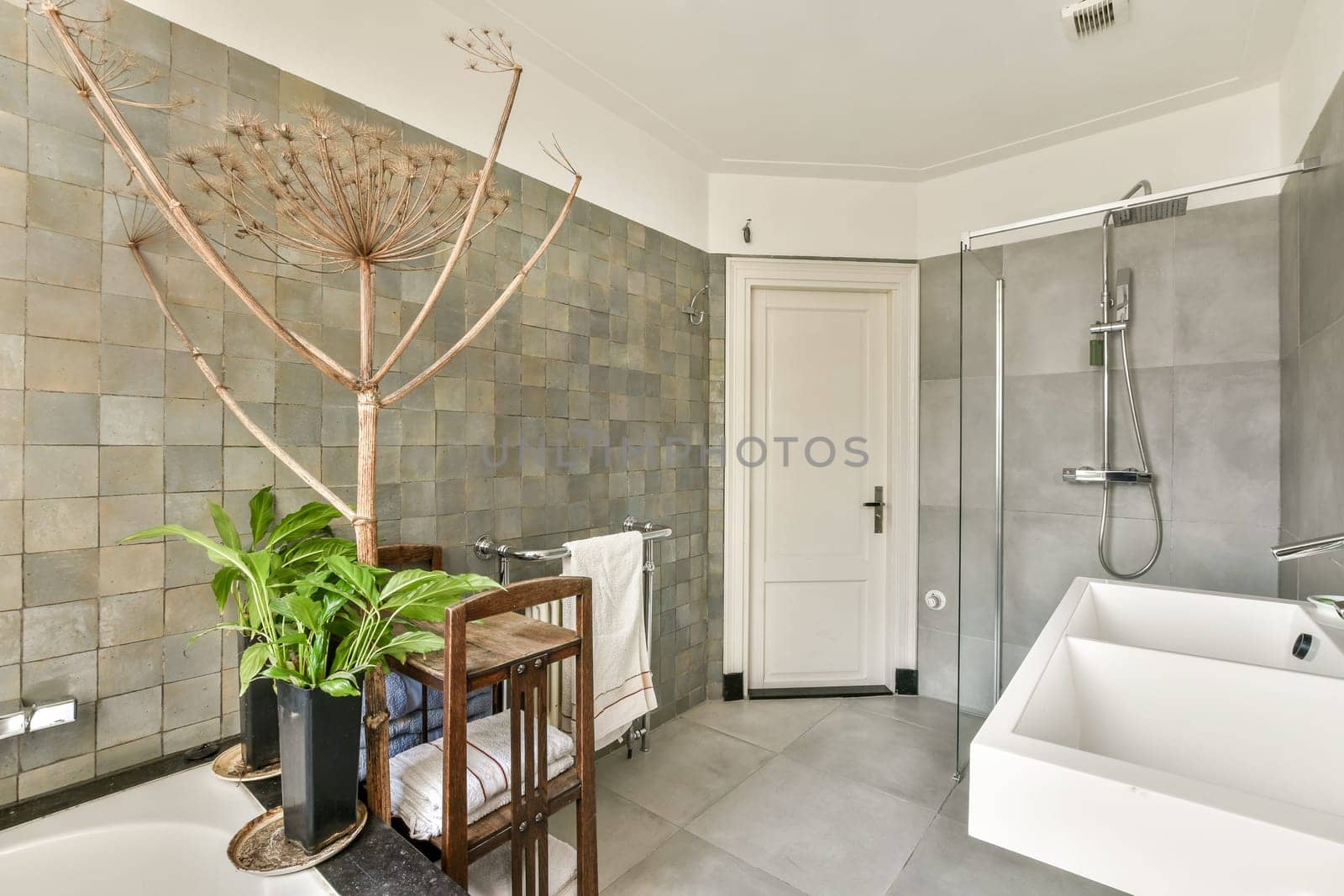 Featuring a minimalist aesthetic, this modern bathroom integrates natural elements like plants and sleek fixtures for a serene experience.