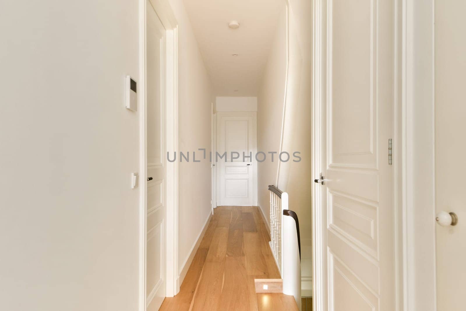 A sleek and minimalist indoor hallway featuring clean lines, wooden flooring, and bright light creating an inviting atmosphere.