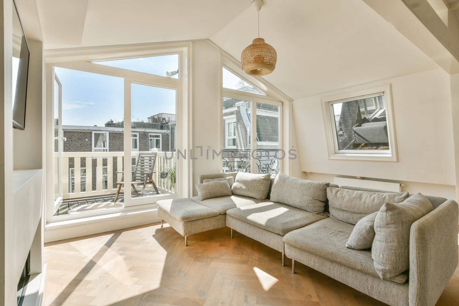 A contemporary living space featuring a cozy sofa, ample natural light from large windows, and a stylish design that invites relaxation and comfort.