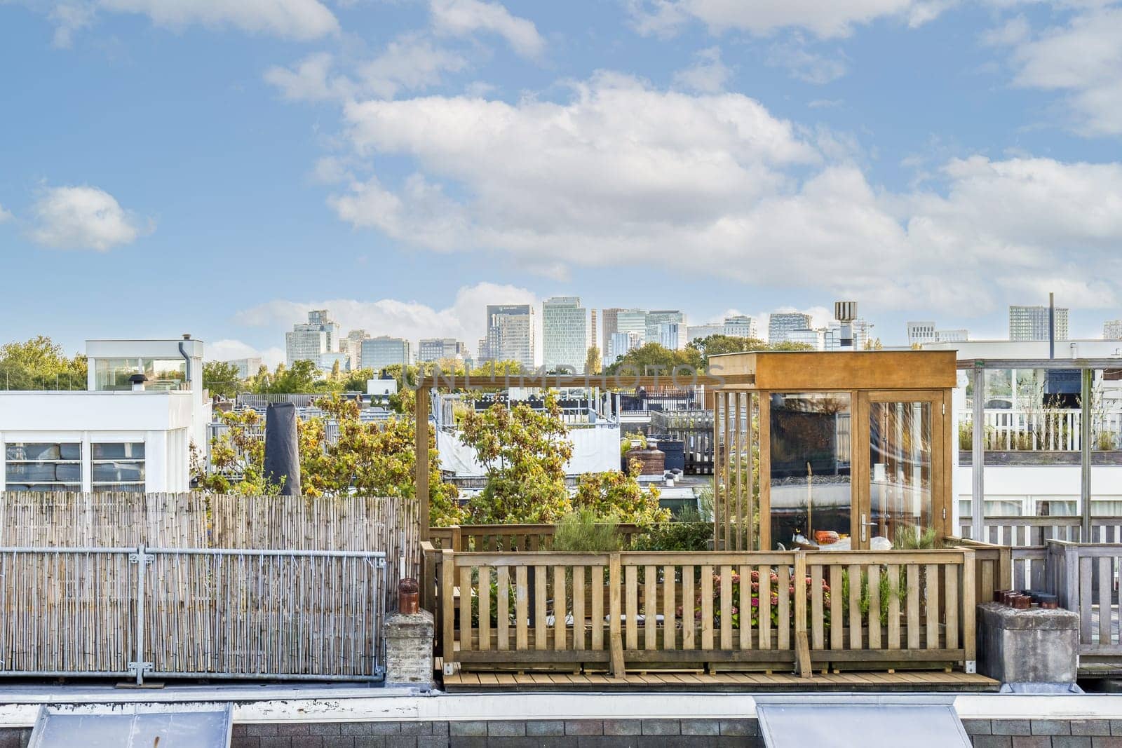 A beautifully designed rooftop garden featuring wooden elements, greenery, and a stunning skyline view of a modern city. Ideal for relaxation and urban escape.