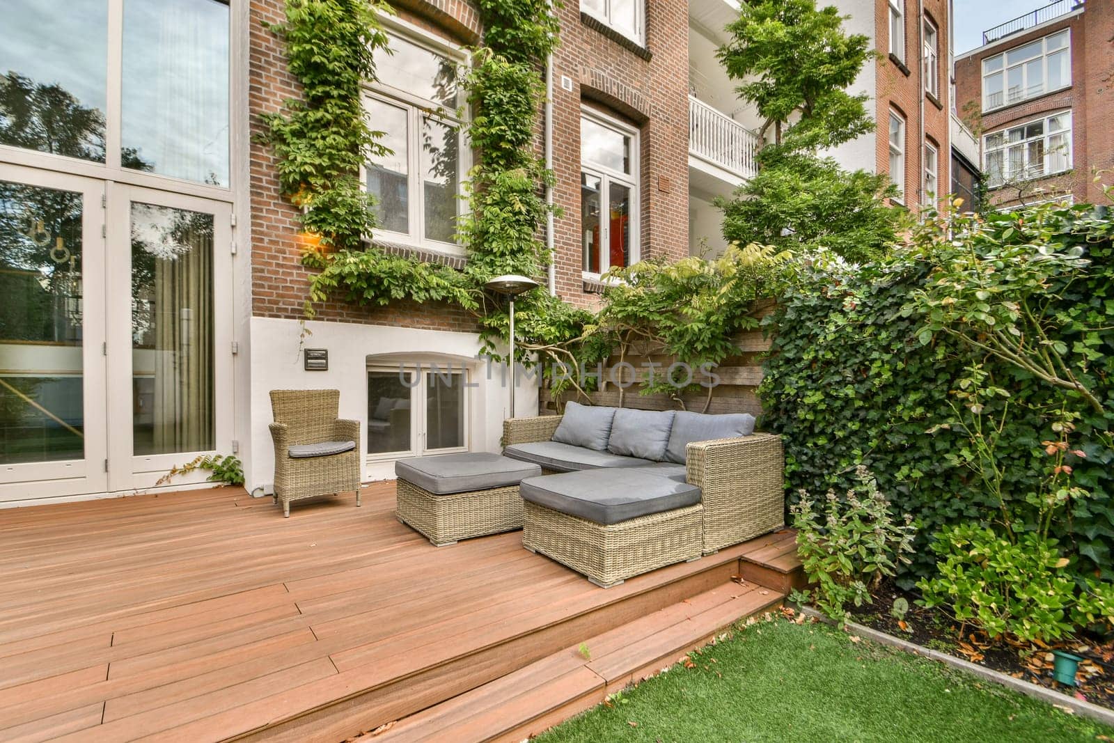 A stylish outdoor area featuring comfortable seating surrounded by lush greenery and modern design elements that enhance relaxation and aesthetic appeal.