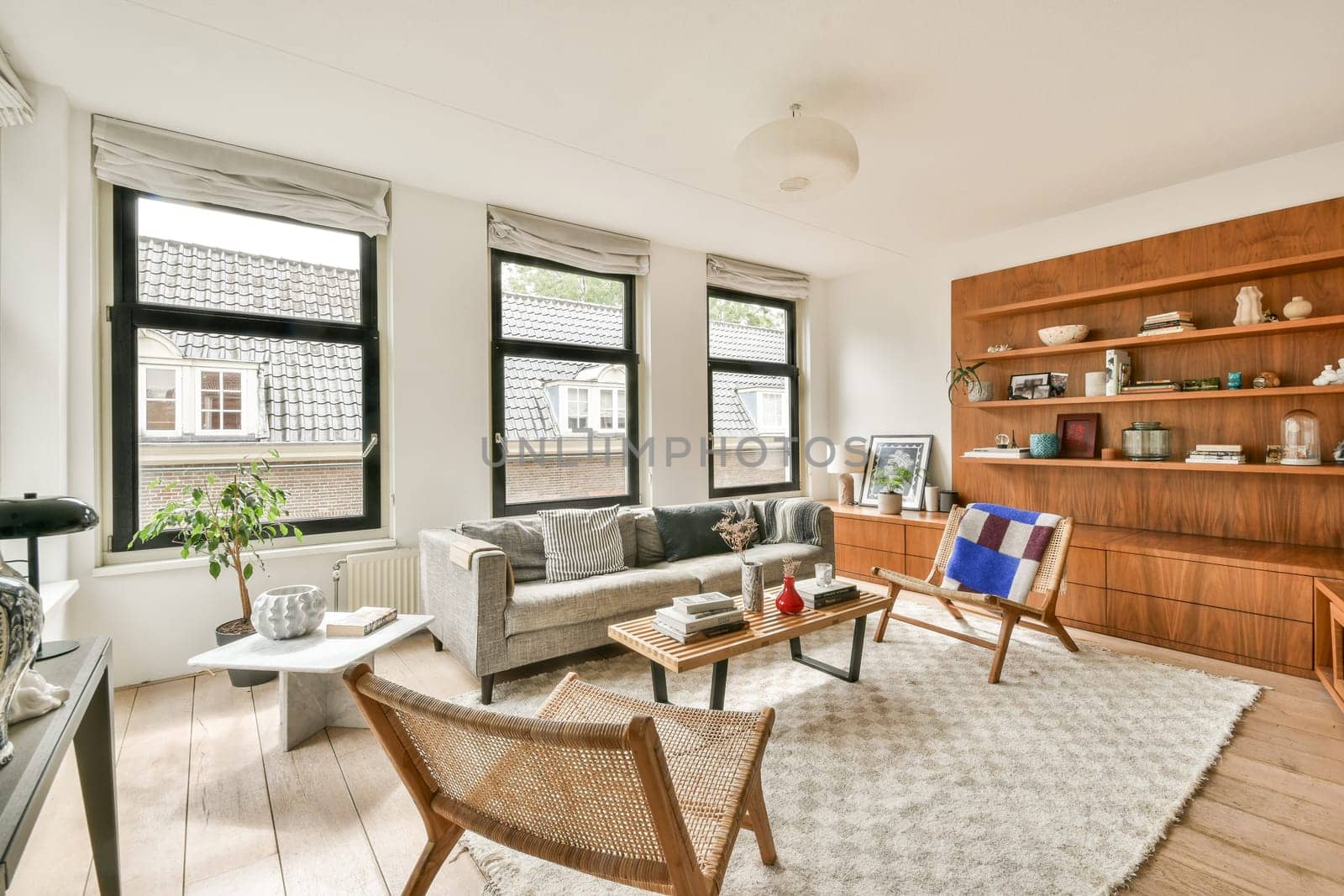A cozy modern living room featuring large windows, stylish furniture, and elegant decor elements. Ambient lighting accentuates the inviting atmosphere.