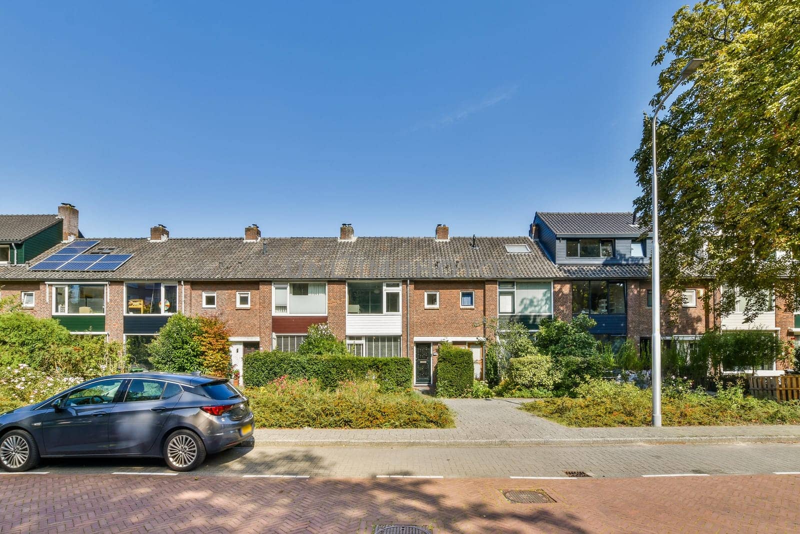 A picturesque view of a cozy neighborhood featuring modern homes, lush gardens, and well-maintained sidewalks, ideal for peaceful living.