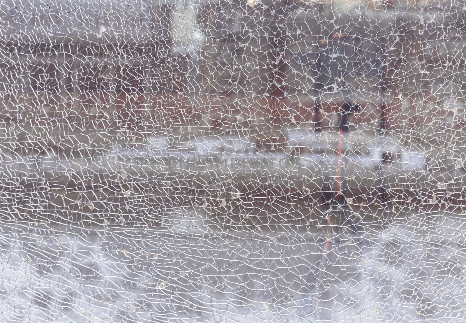 Newcastle, UK - Apr 11, 2025 - Texture of cracked broken glass cracked by impact. Detail of broken tempered glass pane too many small irregular shape pieces holding together, Cracks on the glass surface background, use it as your Wallpaper, Poster and Copy space, Selective focus.