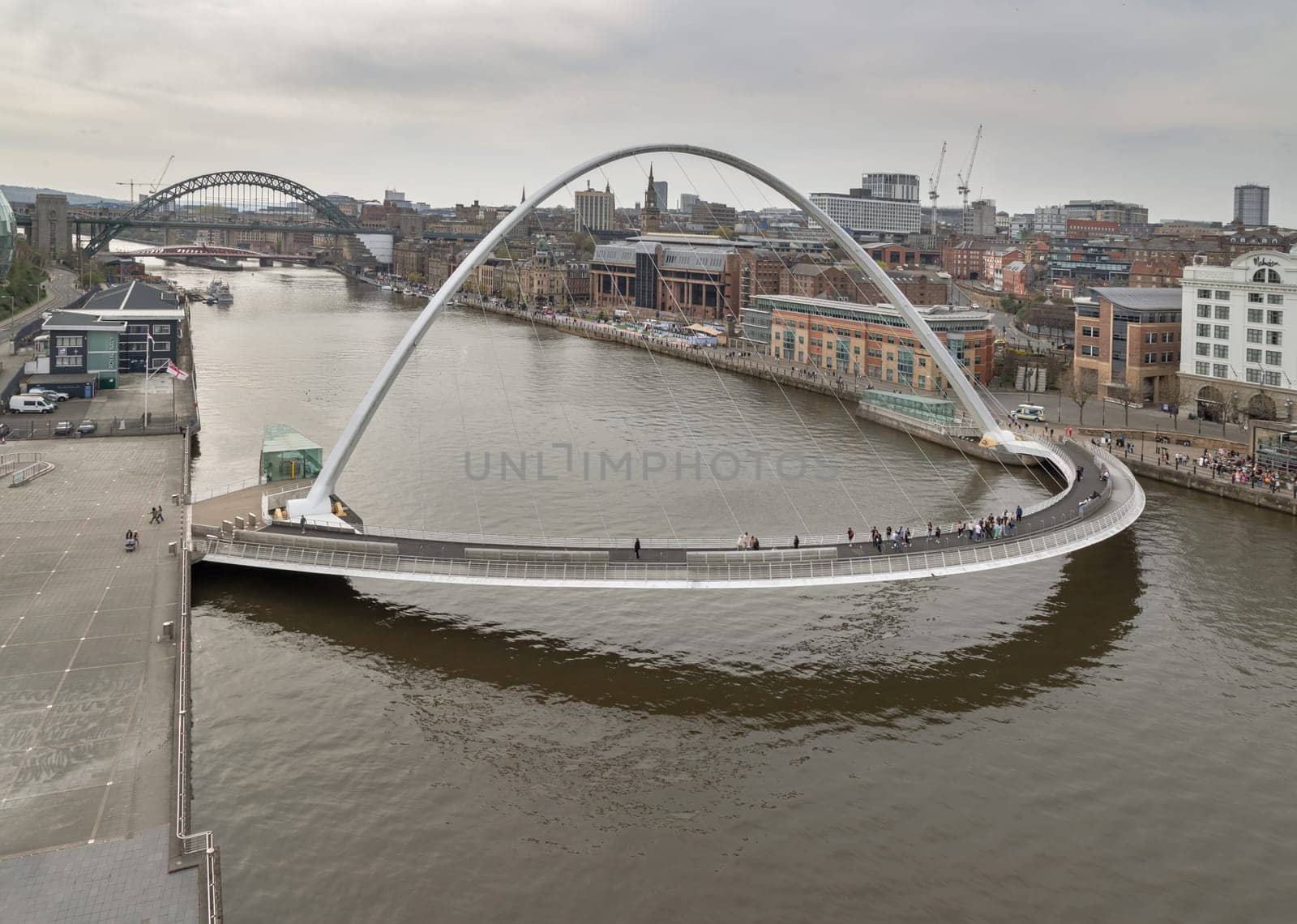 Newcastle, UK - Apr 12, 2025 - Beautiful view of The Iconic gateshead millennium bridge spanning the River Tyne with Ancient buildings and Tyne bridge in the background. use it as your Wallpaper, Poster and Space for text, Selective focus.