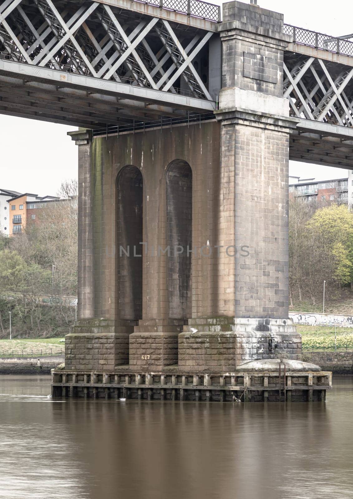 Newcastle, UK - Apr 12, 2025 - Girders and foundations support of The King Edward VII Bridge (Railway viaduct) is a railway bridge spanning the River Tyne between Newcastle upon tyne and Gateshead in the North East of England. King Edward VII Bridge has been described as “Britain’s last great railway bridge”, use it as your Wallpaper, Poster and Copy space, Selective focus.