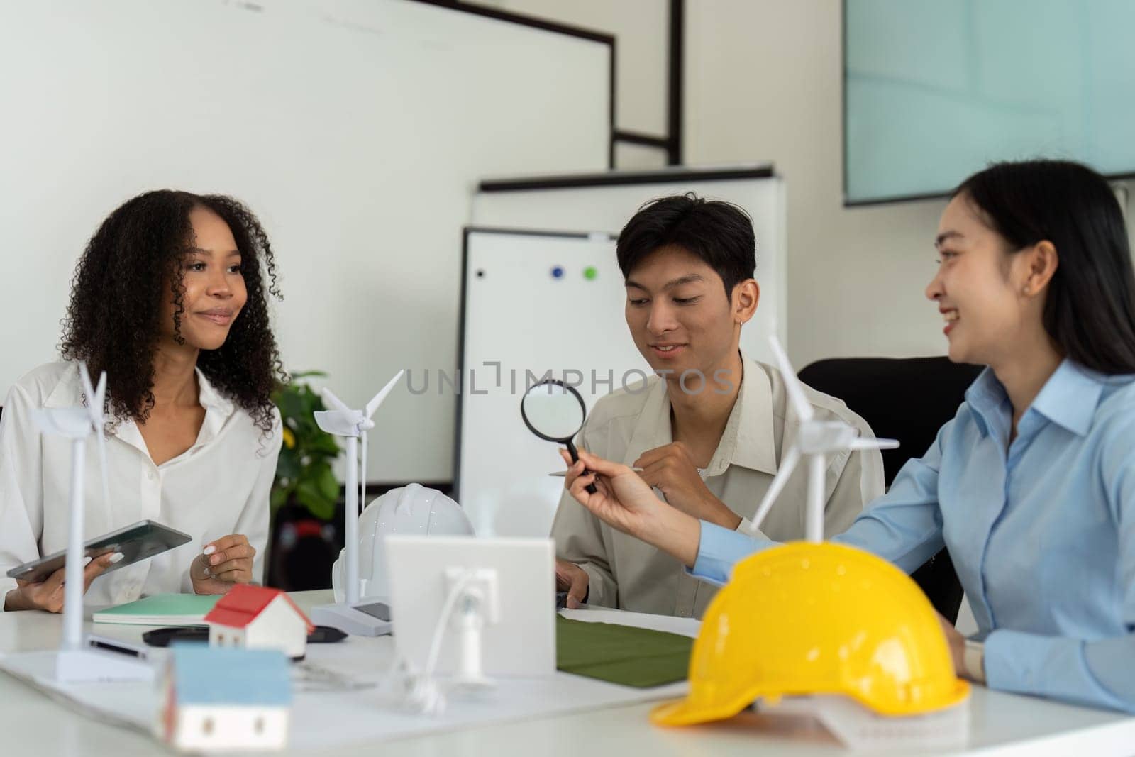 A team of three passionate individuals collaborates on sustainable project designs, focusing on renewable energy and eco-friendly solutions in an interactive environment.