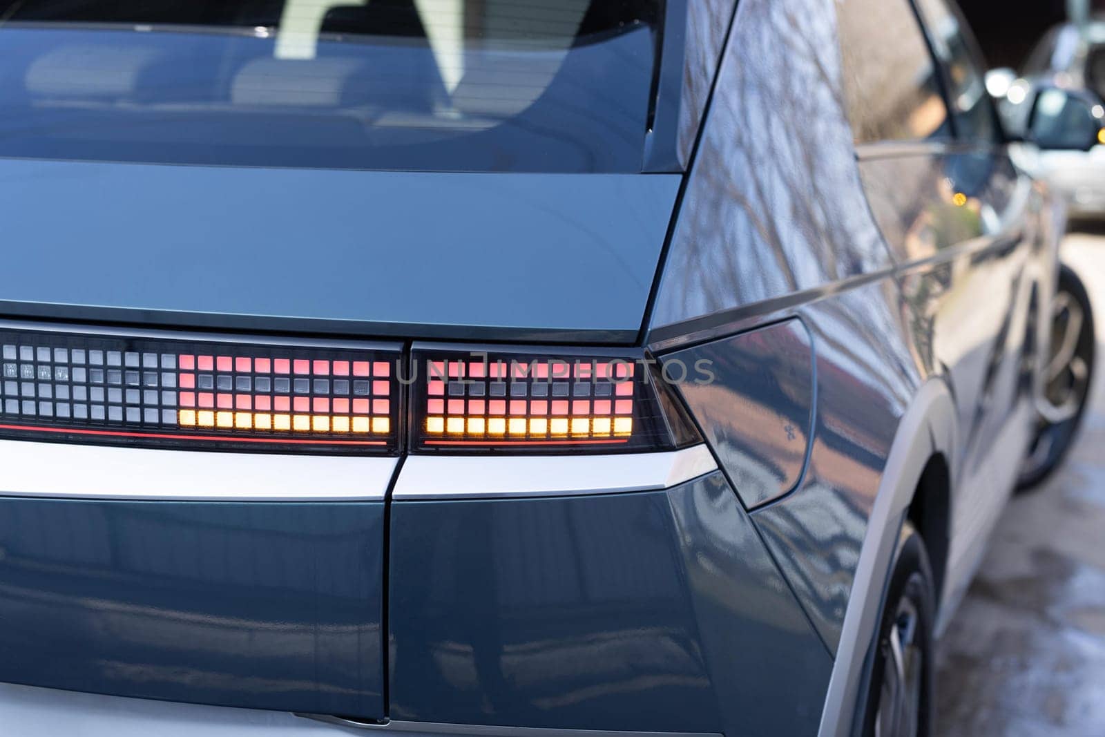 Car taillight. LED red taillight. Closeup tail light of a modern car. Rear light of a car. Rear lamp signals for turning car on street. Signal function to keep them distance. Trunk closeup.