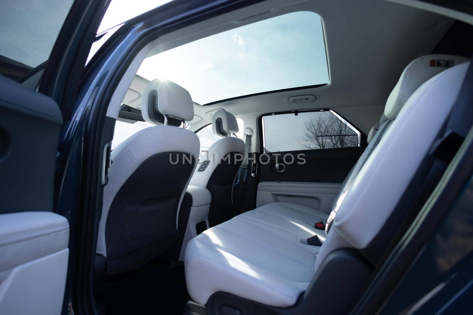 Panoramic glass sun roof in the modern electric car. Clean sunroof and view at the sky from the inside or car interior. The view from the empty car with rear seats.