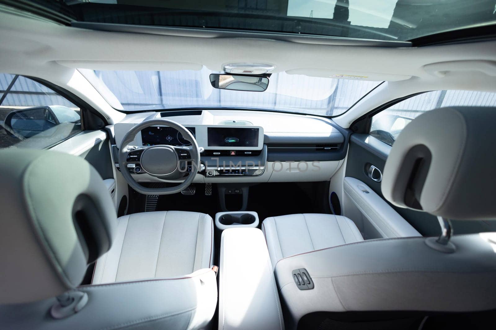 Electric car interior details adjustments. Inside car interior with front seats, driver and passenger, textile, windows, console, gear shift, electric buttons, digital speedometer, steering wheel