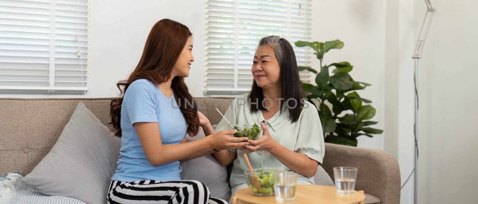 As they share their salads, this mother and daughter duo strengthens their connection, emphasizing healthy living and familial support in a cozy environment.