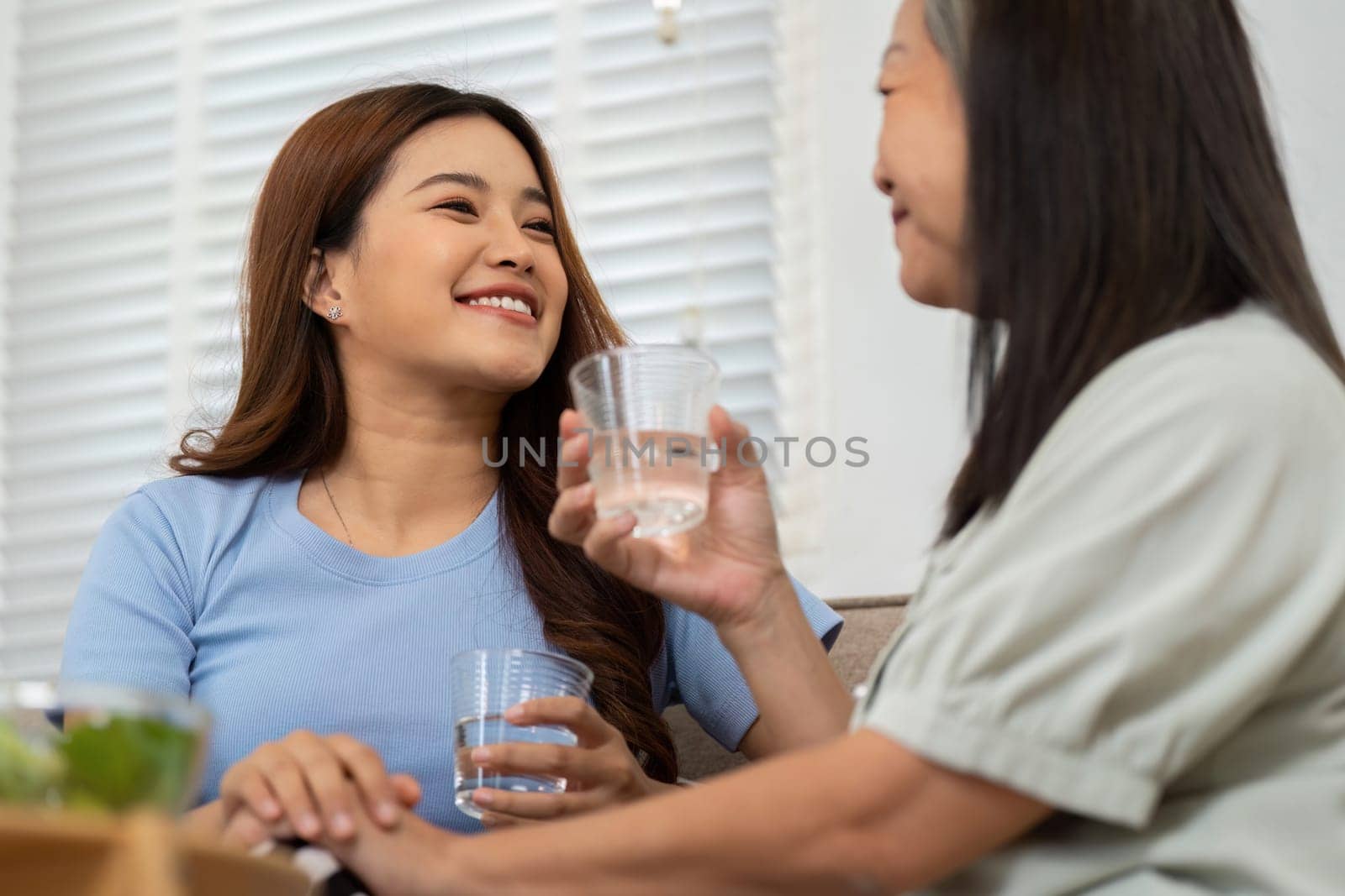 Both women share a smile, celebrating their health and good choices while engaging in meaningful conversation over water.