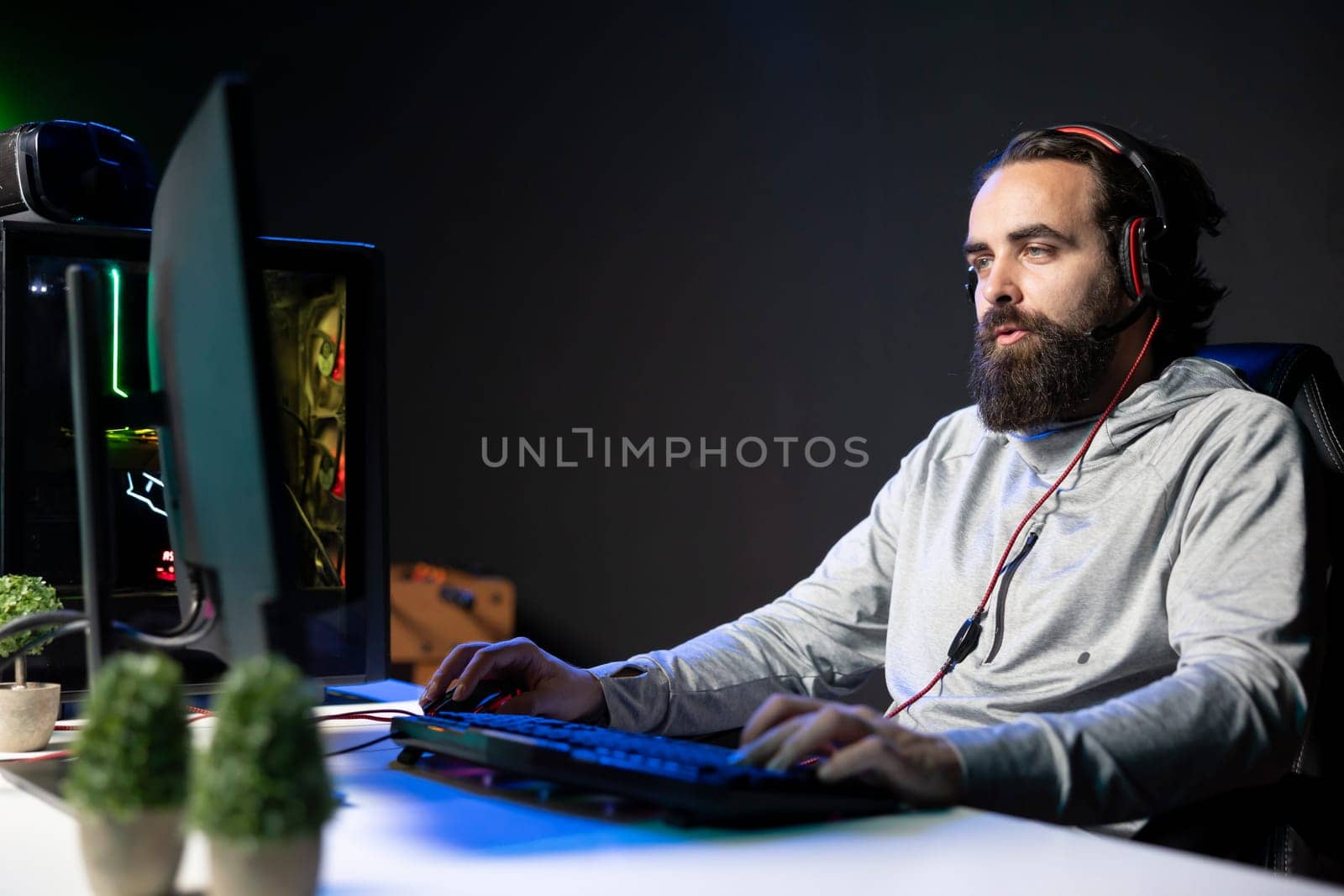 Charismatic streamer in RGB lit studio chatting with audience, inviting them to pick game for him to play. Gamer interacting with viewers watching his livestream, entertaining fans