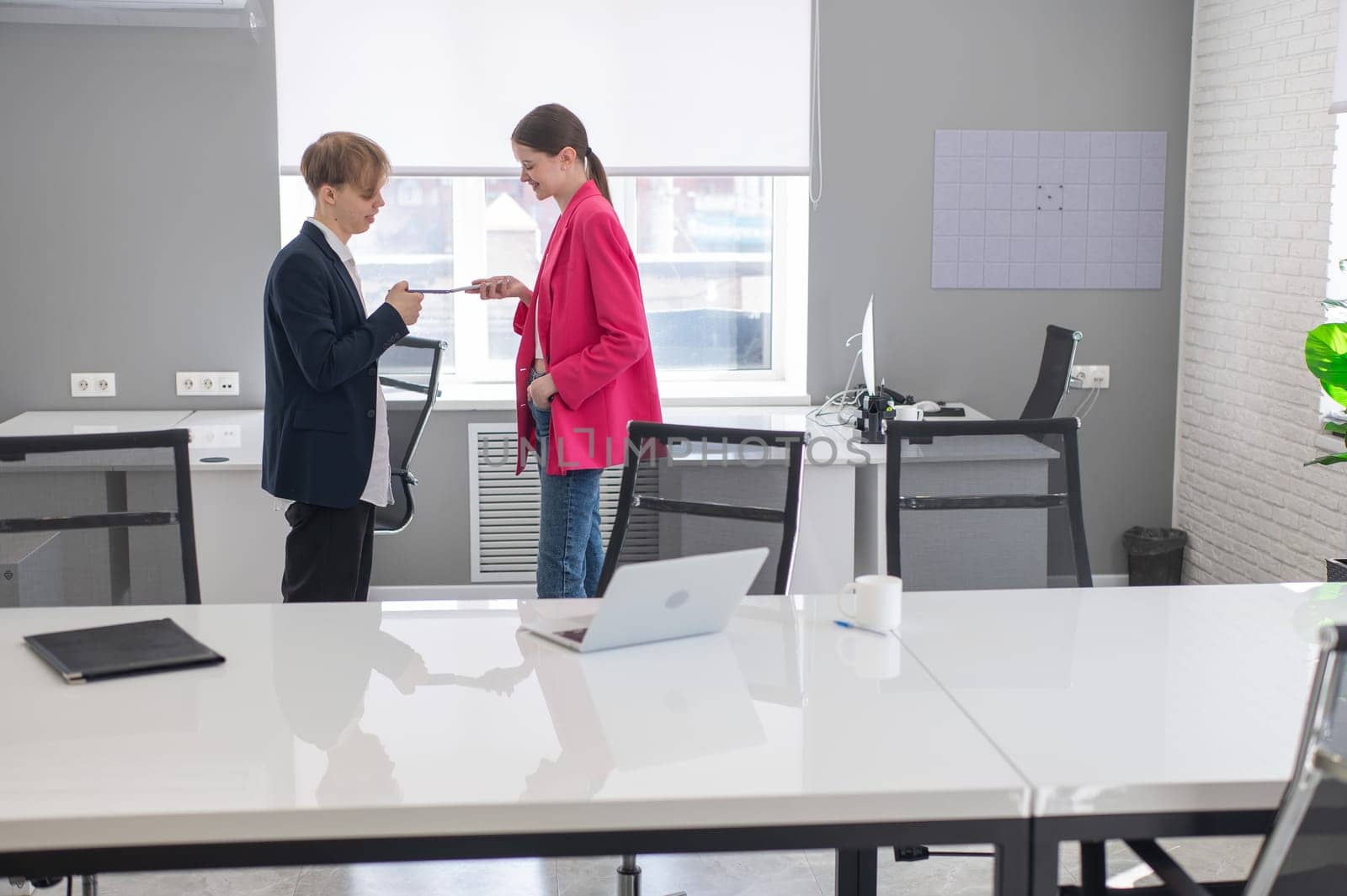 Colleagues use smartphones at work in the office