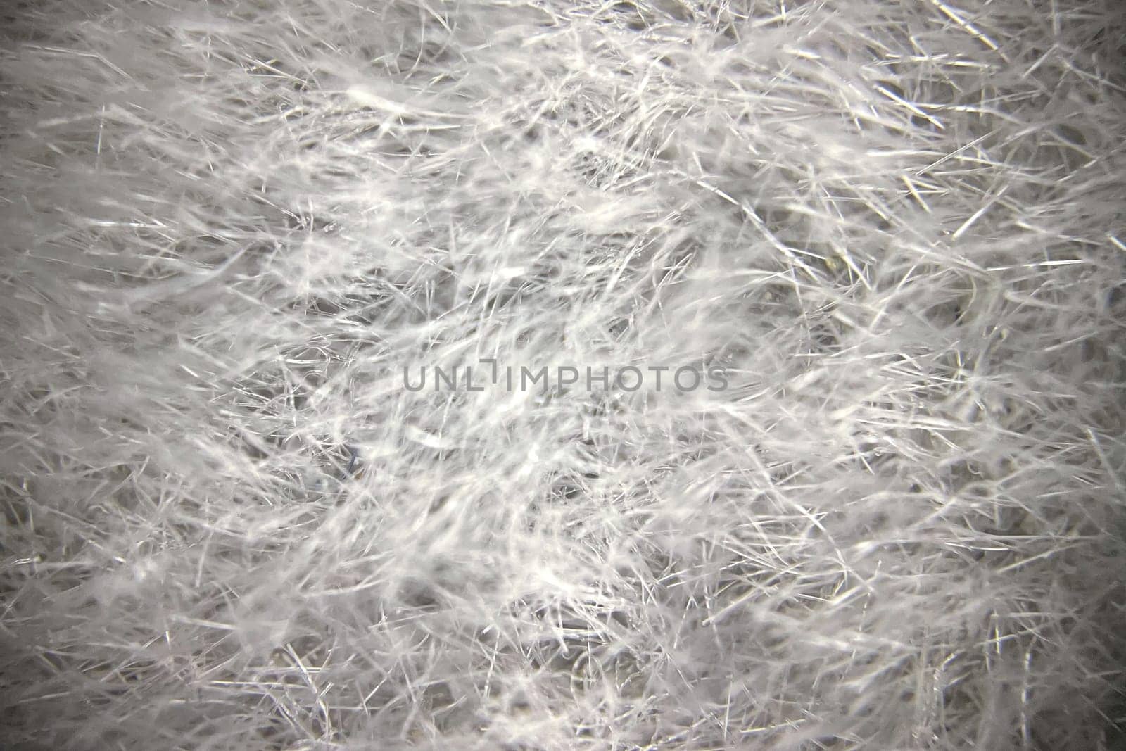 Close-up view of fabric fibers under a microscope, revealing intricate texture and structural complexity.