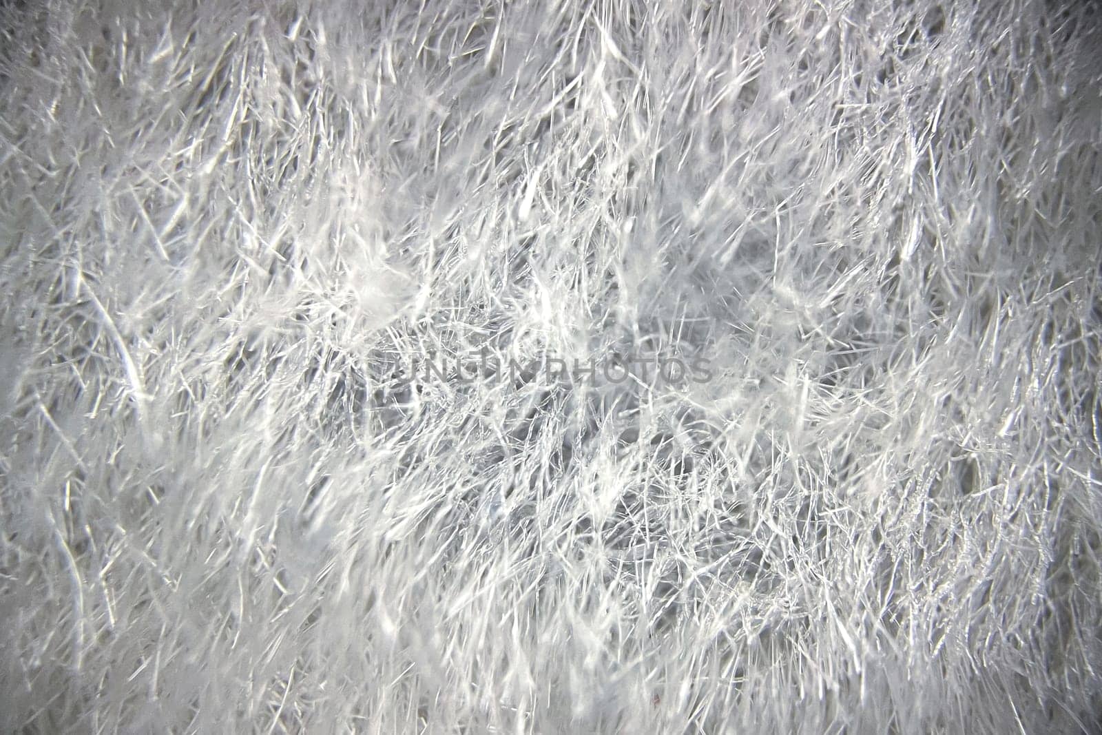 Close-up view of fabric fibers under a microscope, revealing intricate texture and structural complexity.