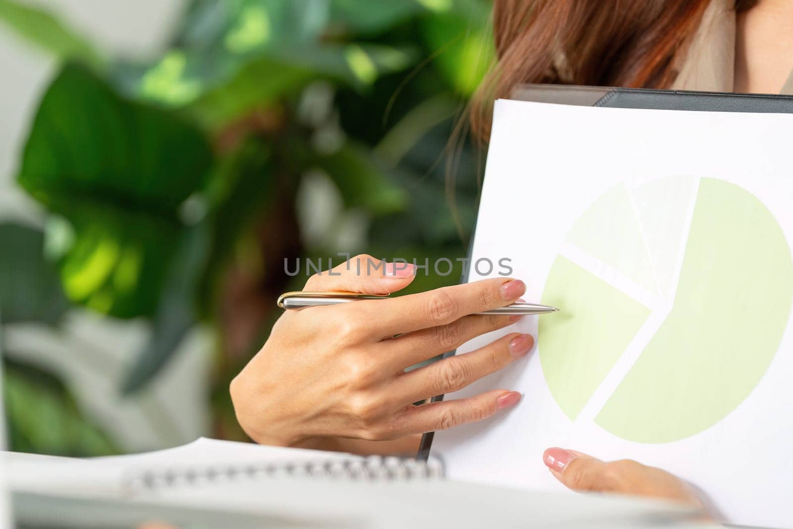 Engaging with colleagues remotely, a woman enthusiastically explains her findings on a pie chart, showcasing data-driven insights in a professional setting.