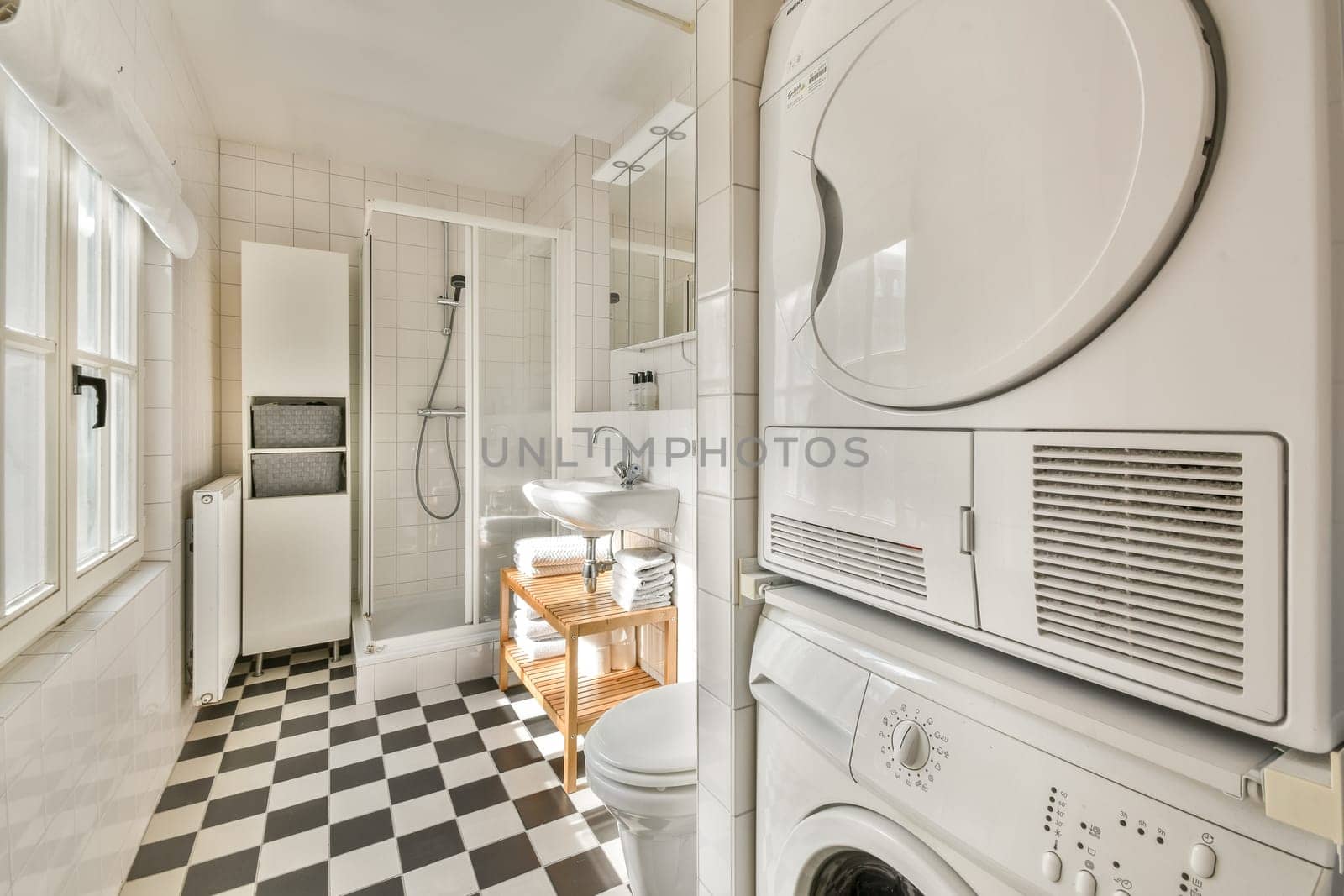 A stylish bathroom featuring modern laundry appliances alongside sleek fixtures, clean lines, and a checkered floor design that enhances the overall aesthetic.