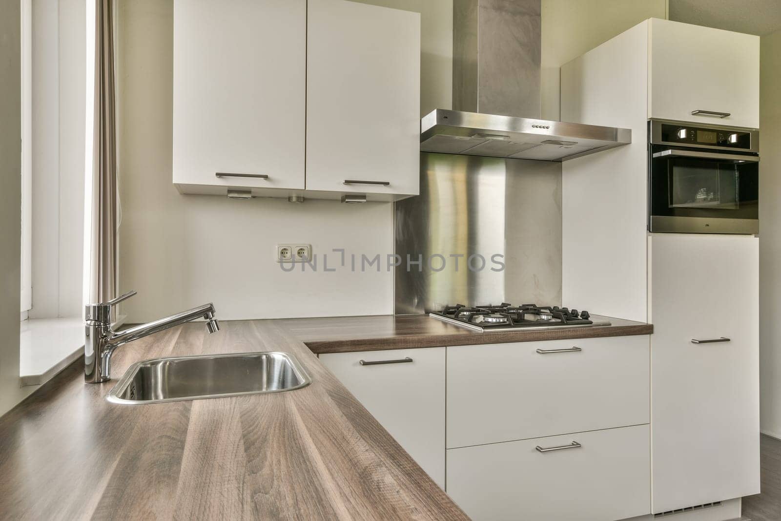 This sleek kitchen features a contemporary layout with a minimalist design, clean lines, and elegant cabinetry. Ideal for functional cooking and style.