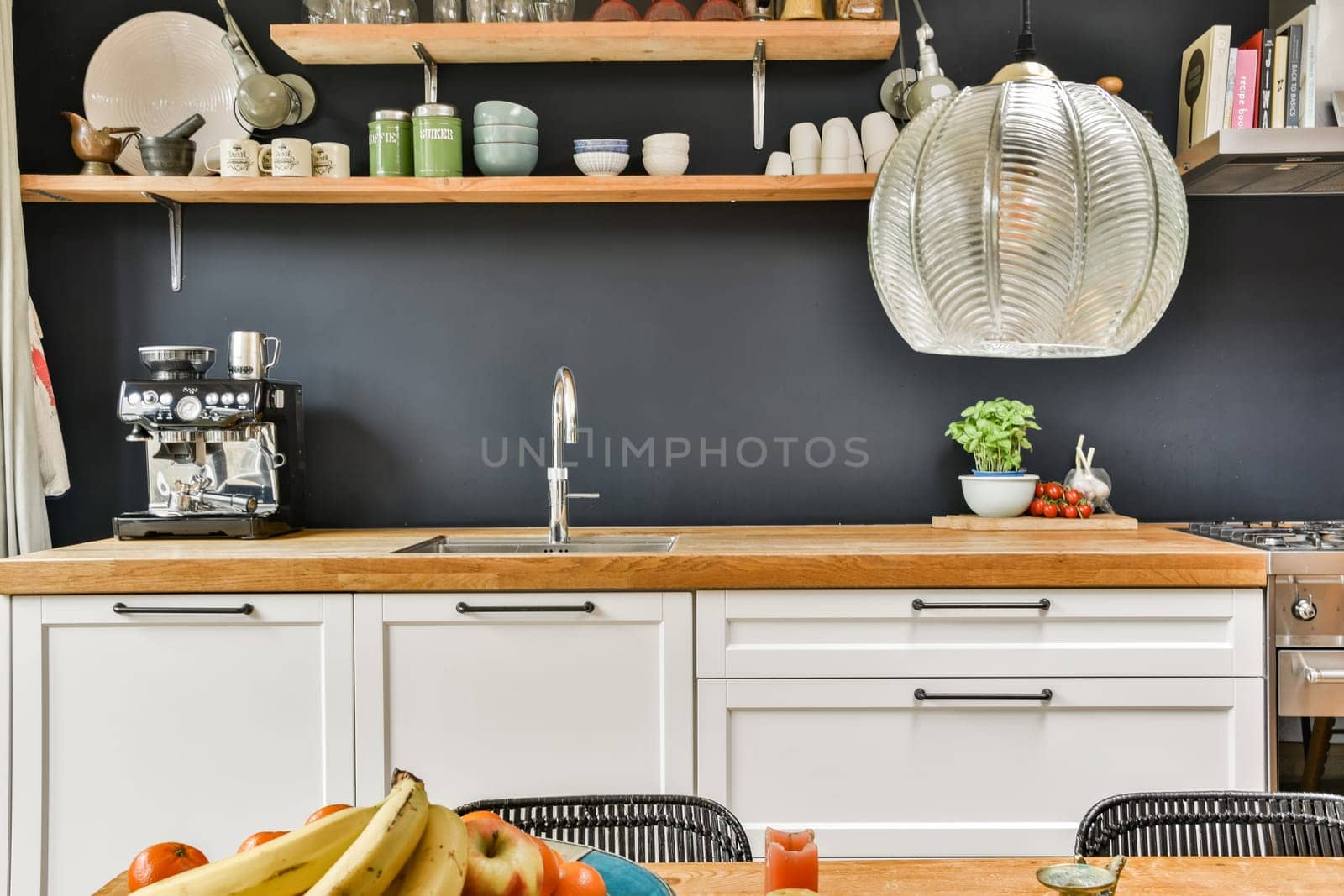 A contemporary kitchen featuring sleek white cabinets, elegant wooden countertops, and modern appliances arranged harmoniously for an inviting culinary space.