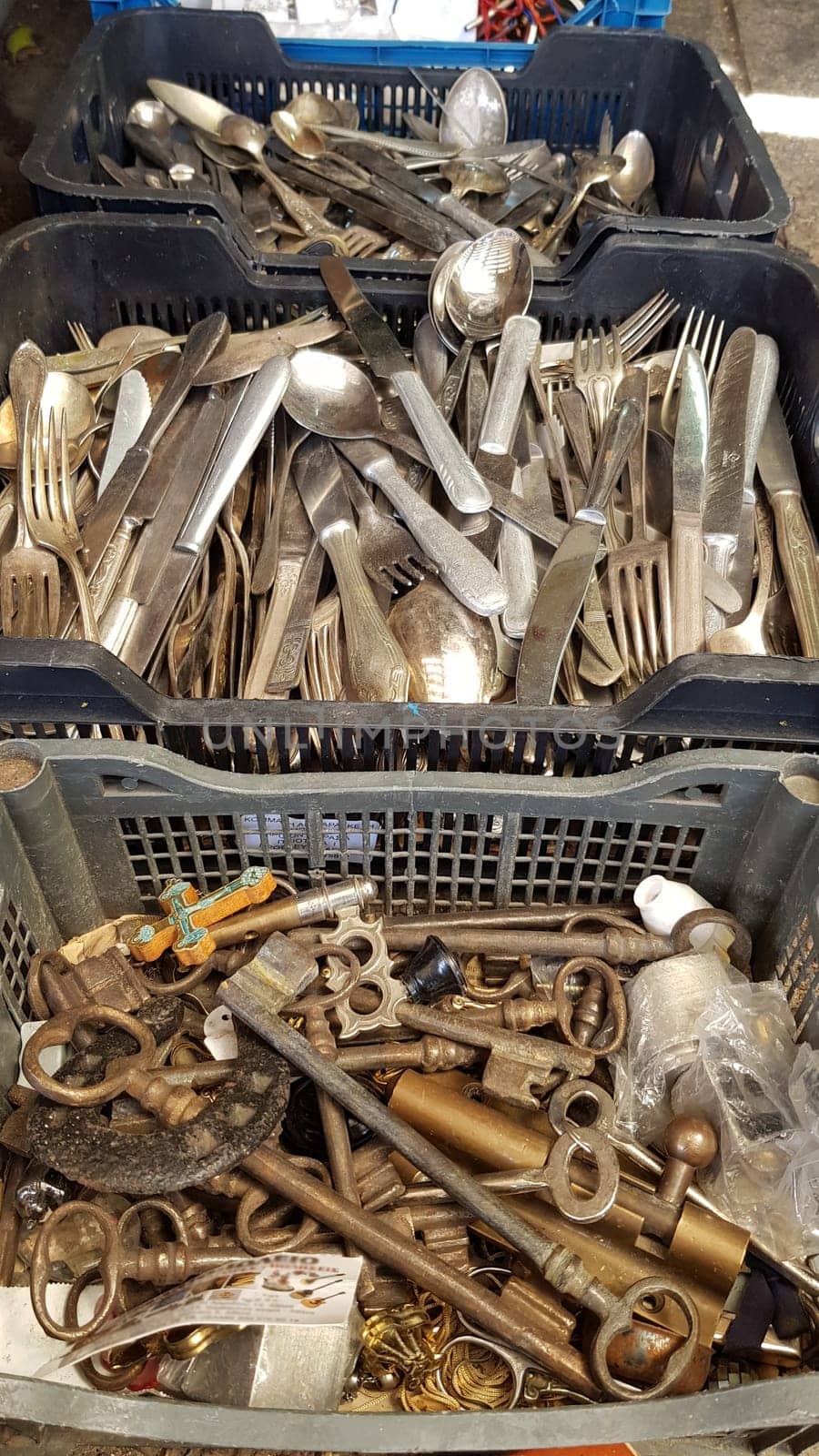 Selective focus vintage keys and cutlery inside old boxes at flea market in Athens. Garage sale of antique items
