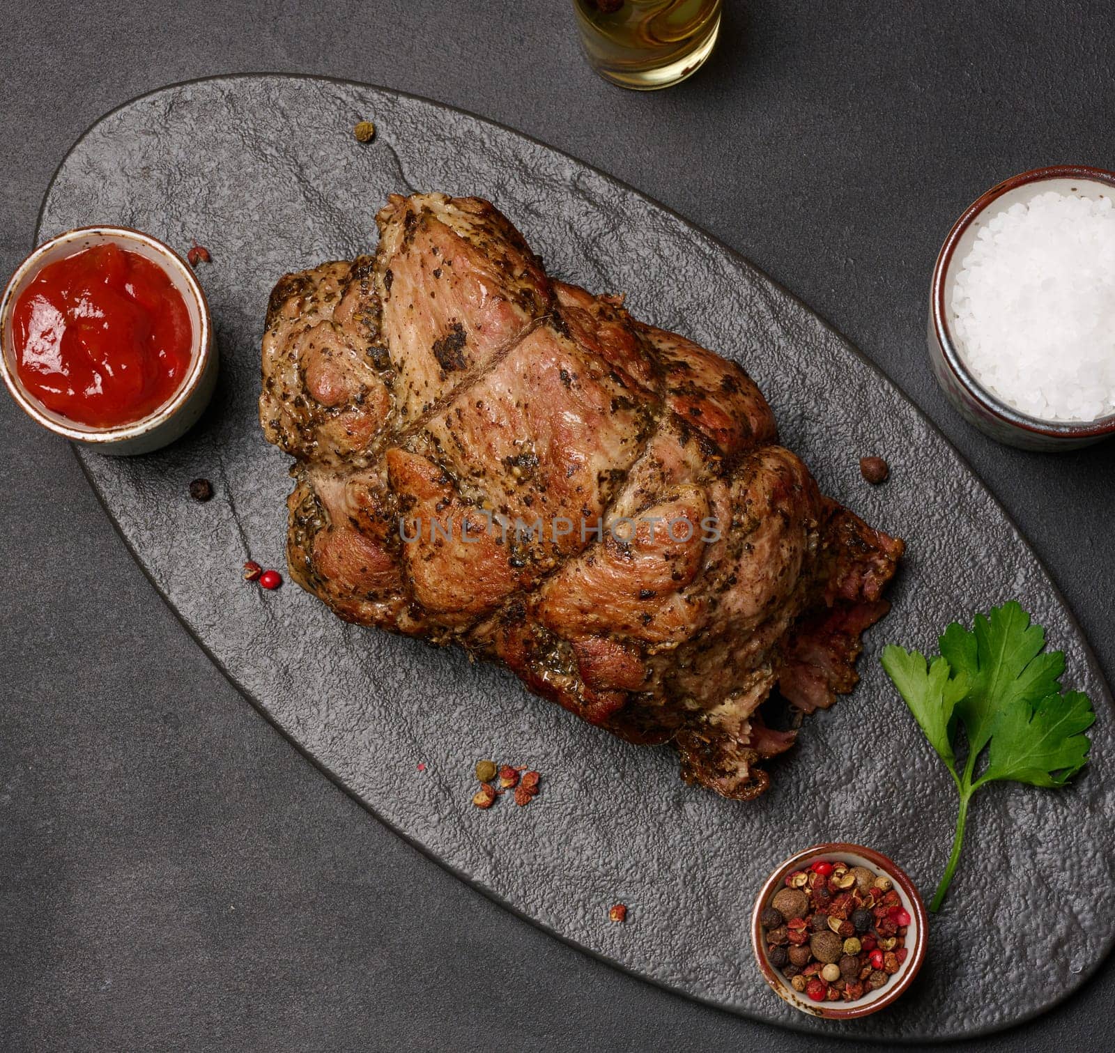 Baked pork collar with spices on a wooden board, delicious and juicy meat
