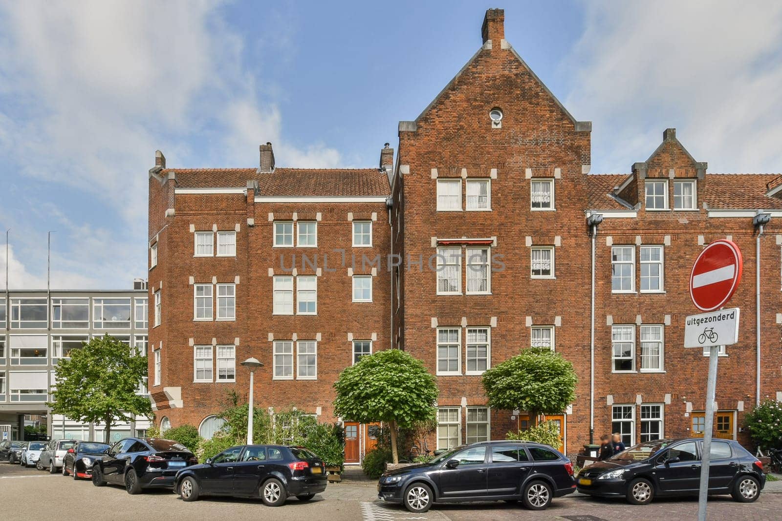 A striking blend of historic brick architecture set against modern developments, showcasing urban evolution and design contrast.