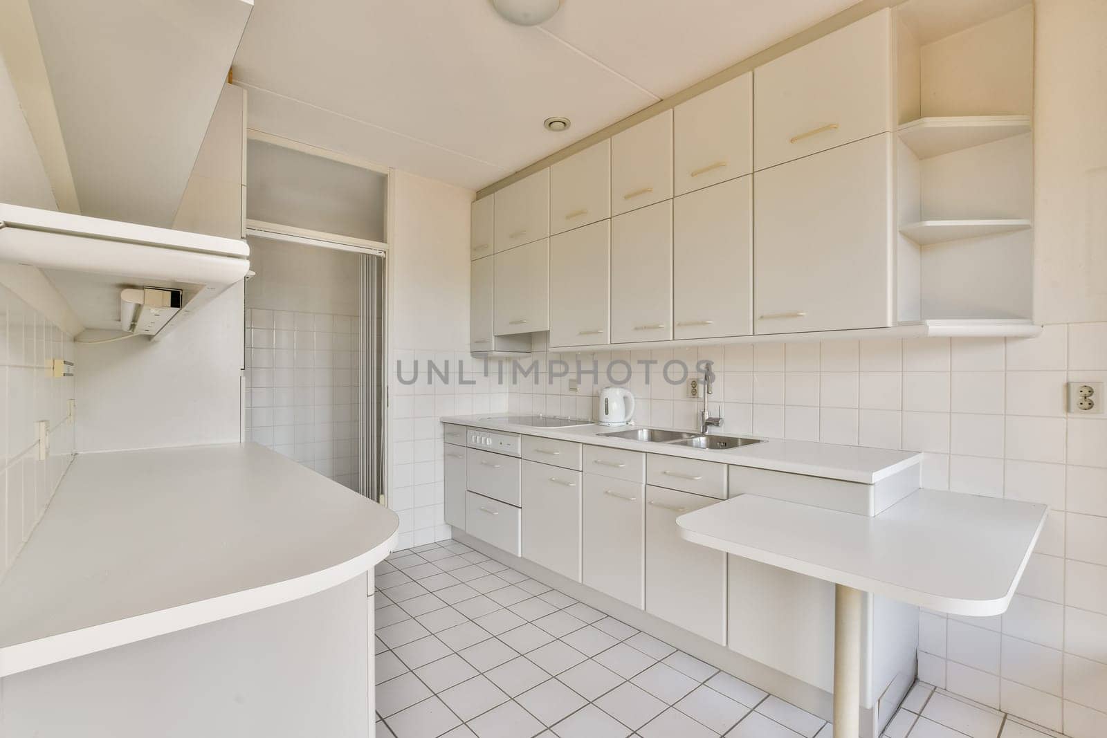 A spacious and sleek modern kitchen featuring white cabinetry, minimalist design, and clean lines, beautifully arranged for functionality and style.