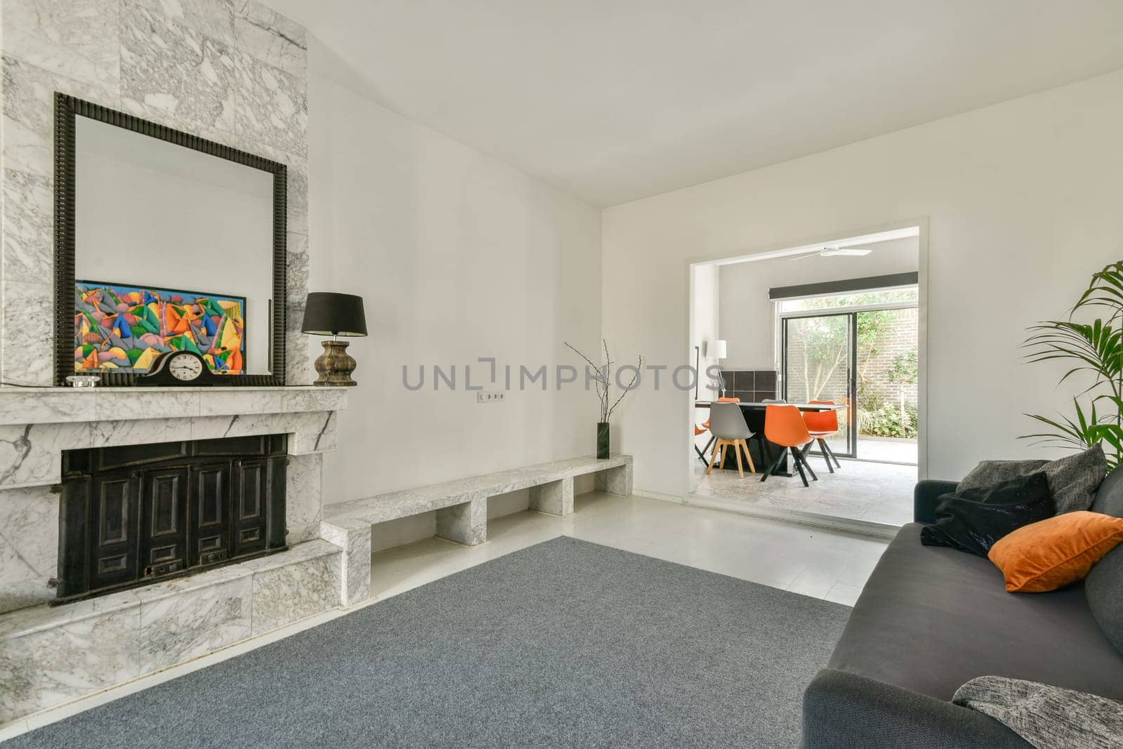 A stylish modern living room featuring a marble fireplace, contemporary art, and a cozy seating area that blends comfort with sophistication.