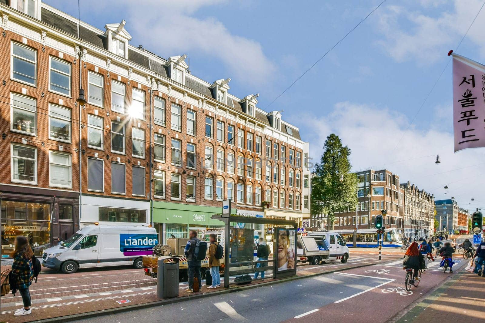 A vibrant city street showcasing historical buildings, quaint shops, and pedestrians enjoying the sunny day, creating a lively urban atmosphere.