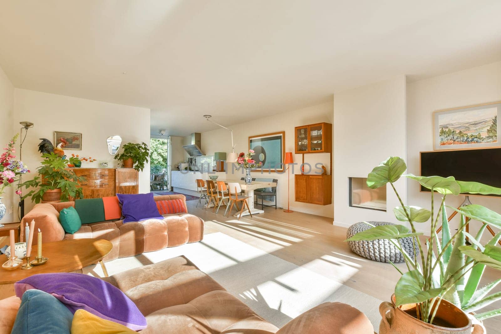 A beautifully designed modern living room featuring vibrant decor, comfortable seating, and ample natural light, creating a warm and inviting atmosphere for relaxation.