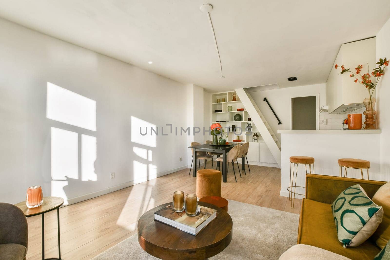 A stylish modern living room featuring minimalist design, natural light, and contemporary furniture enhances comfort and aesthetics.