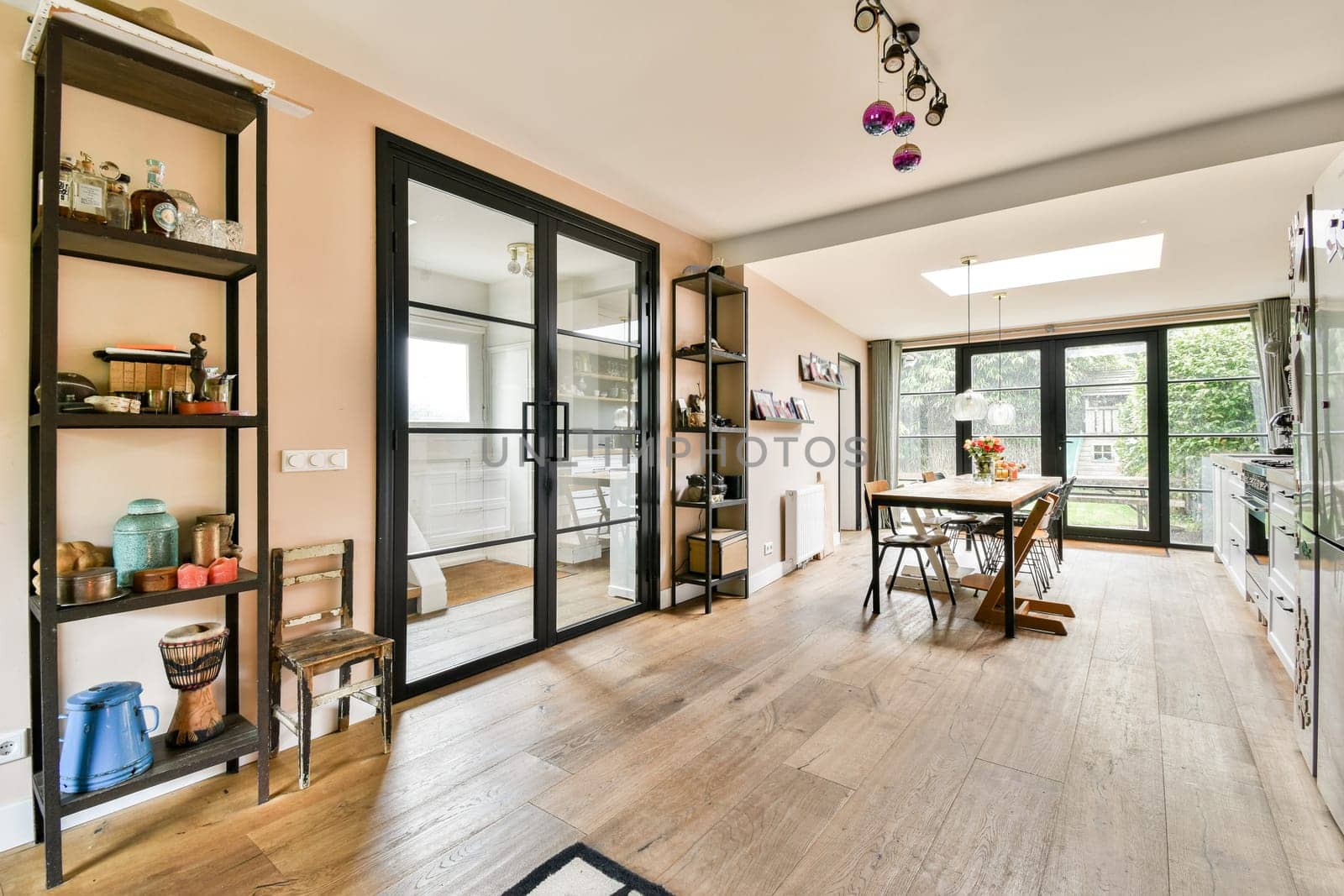 A bright and spacious kitchen featuring elegant decor, wooden flooring, and large windows. Ideal for gatherings and culinary activities.