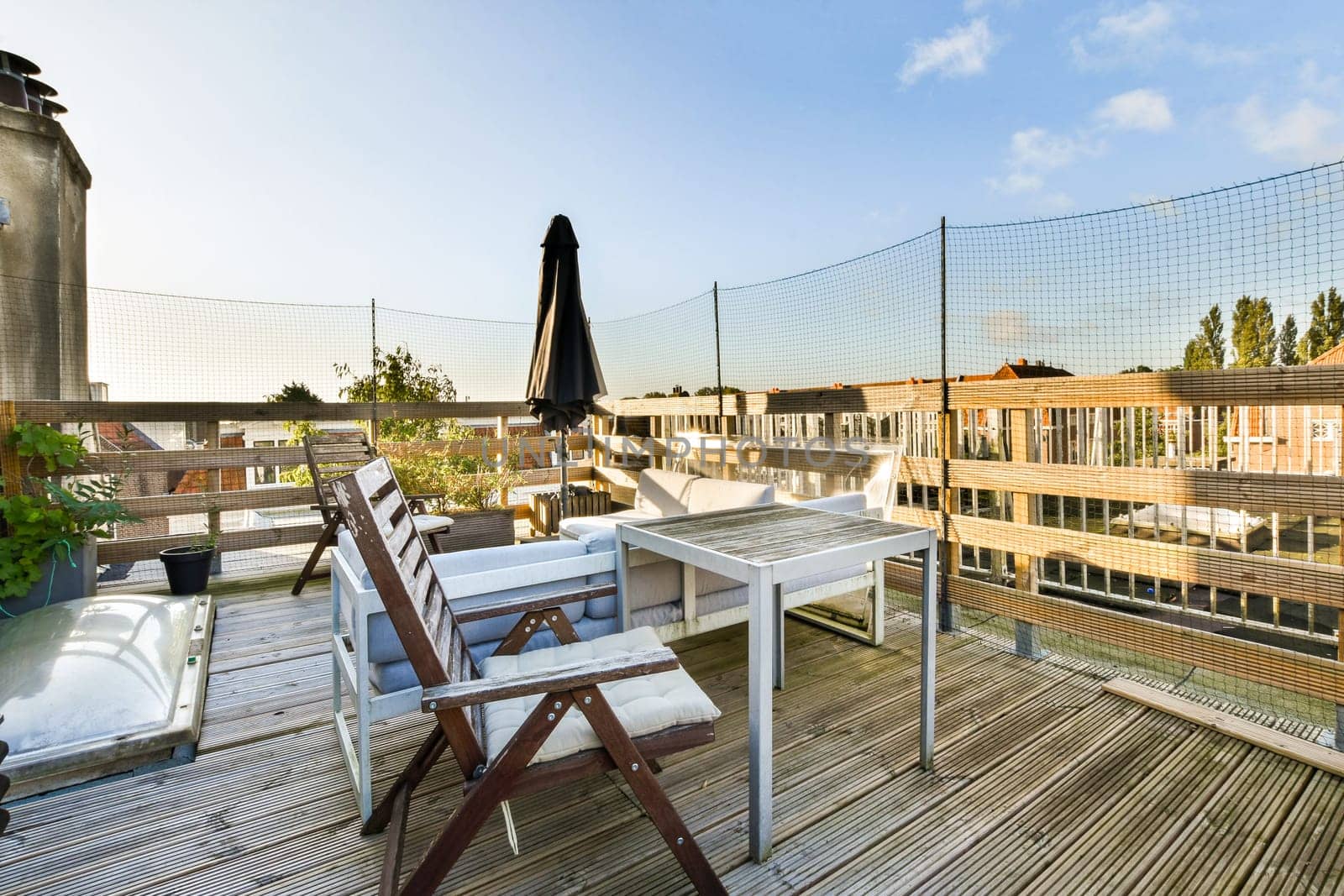 A beautifully designed rooftop deck featuring modern outdoor furniture, gentle sunlight, and greenery that creates a serene urban retreat.