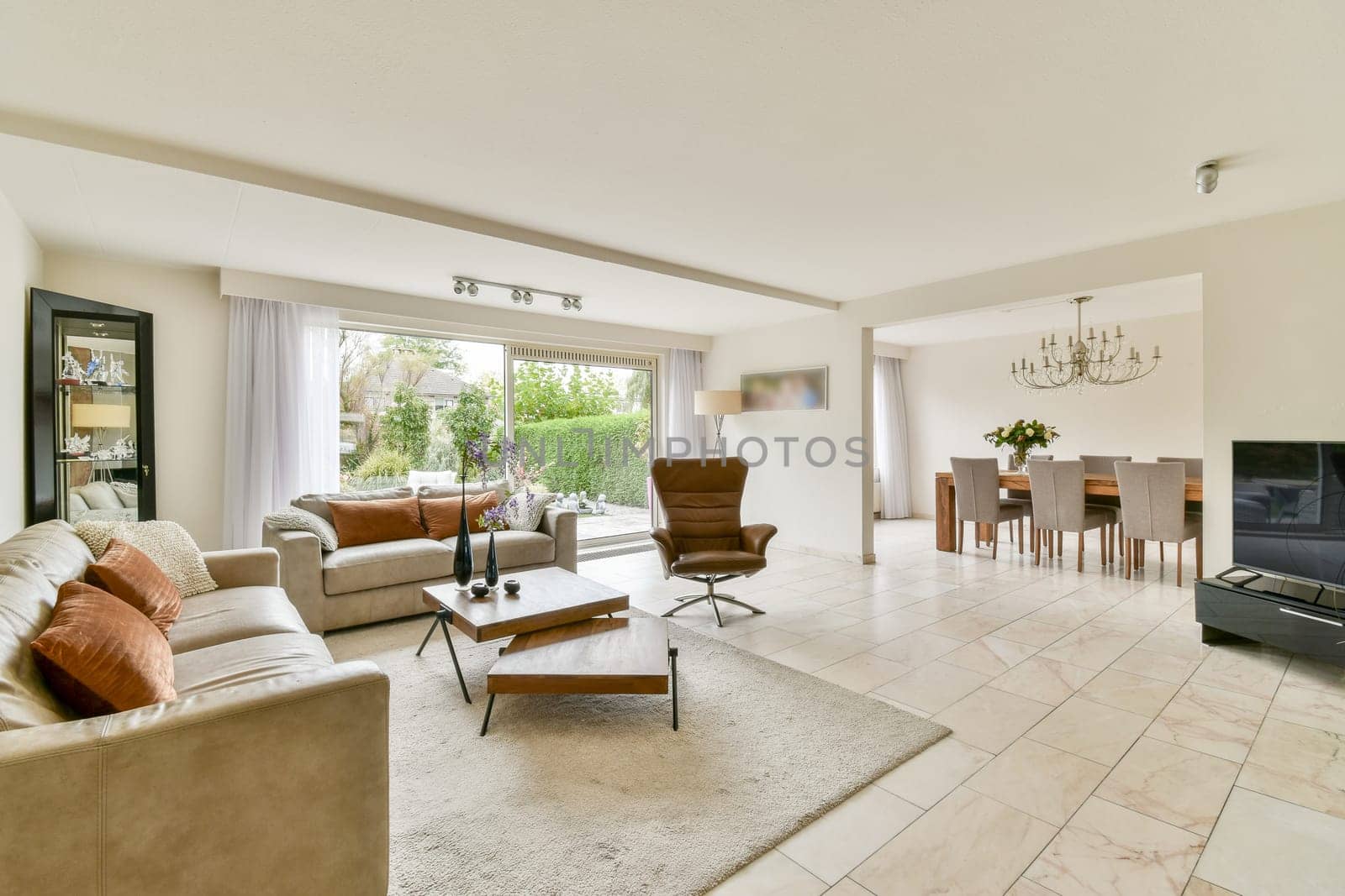 A stylish modern living room featuring elegant furniture, large windows, and a warm color palette that creates an inviting atmosphere for relaxation and social gatherings.