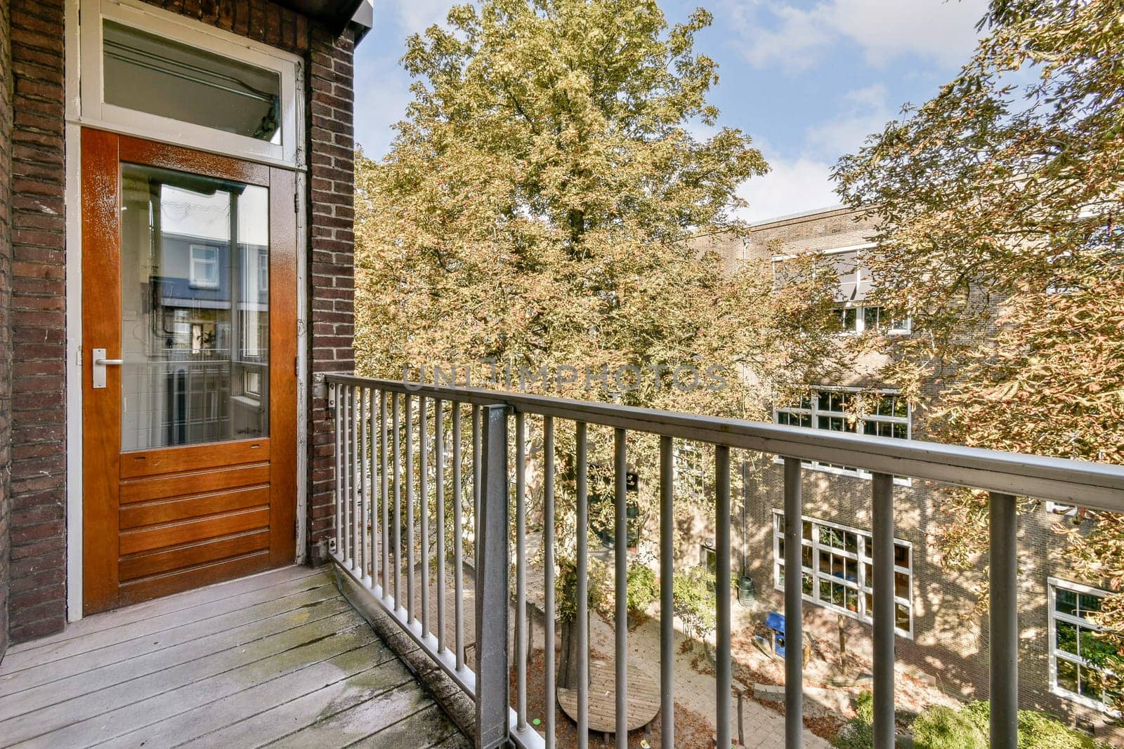 A stylish modern balcony view showcasing lush greenery and well-maintained foliage, blending urban architecture with nature's beauty.