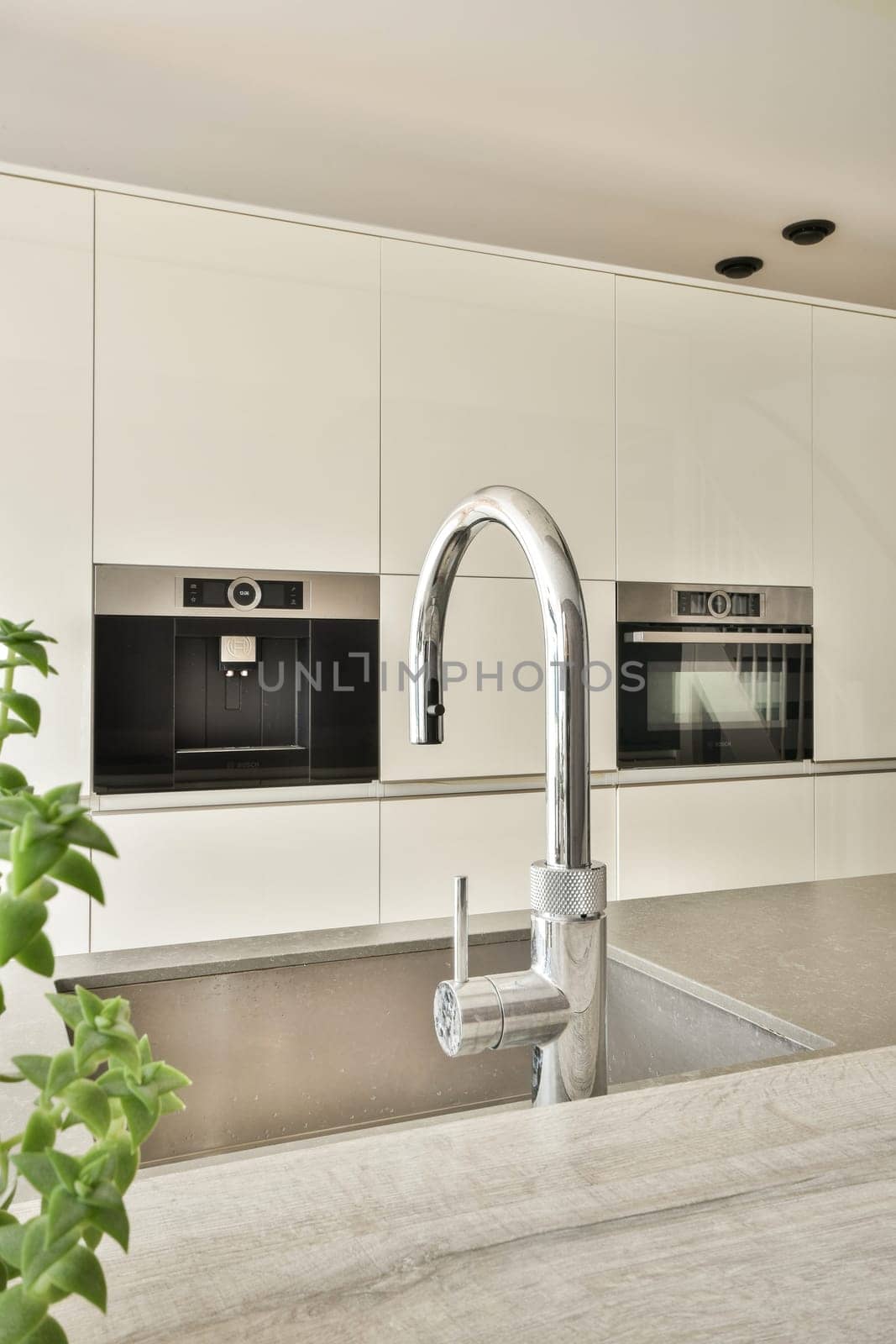 Contemporary kitchen featuring a minimalist design, sleek stainless steel faucet, and elegant cabinetry. A harmonious blend of style and functionality.