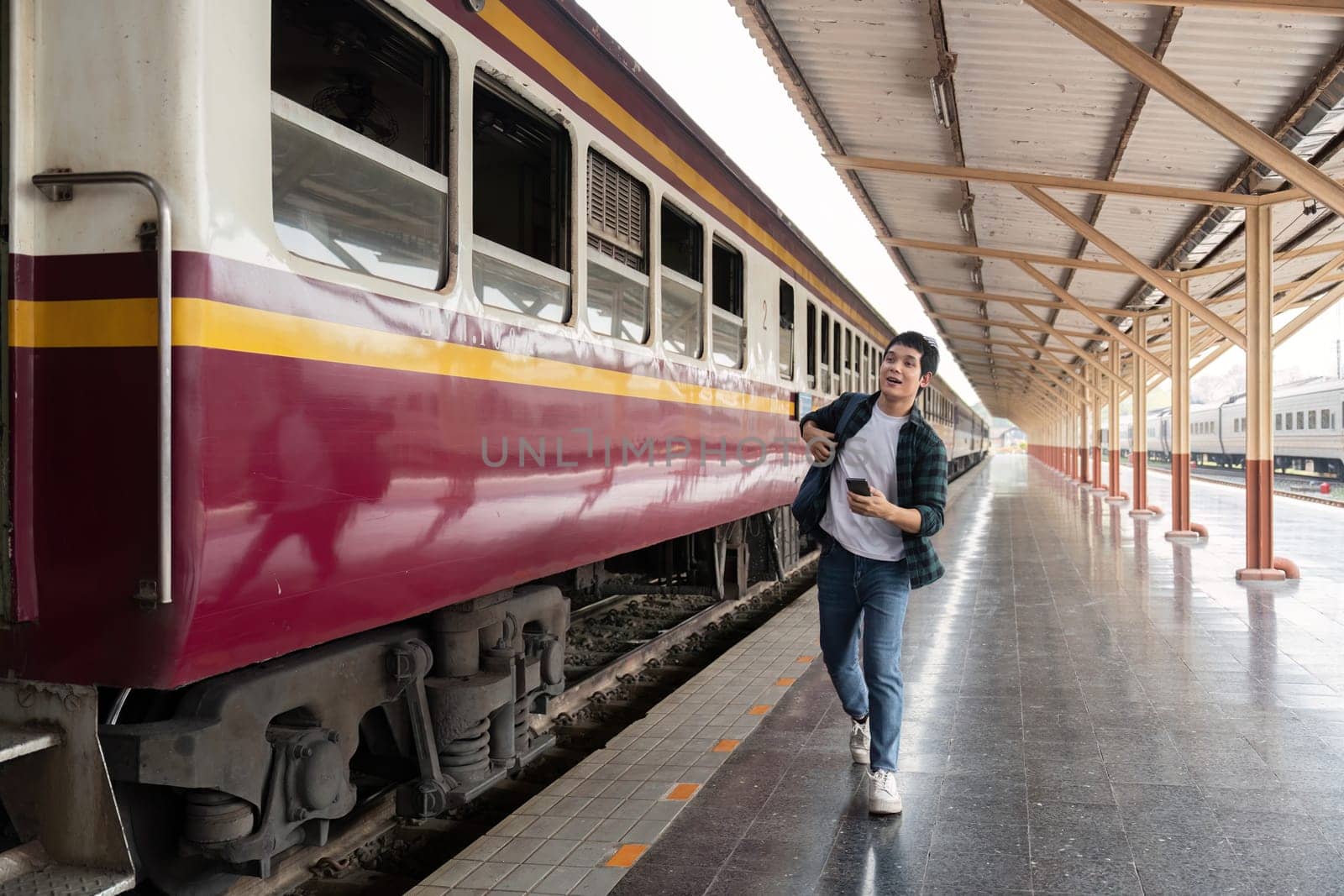 With a confident stride, a traveler walks alongside the train, embodying the essence of exploration and anticipation for what's next.